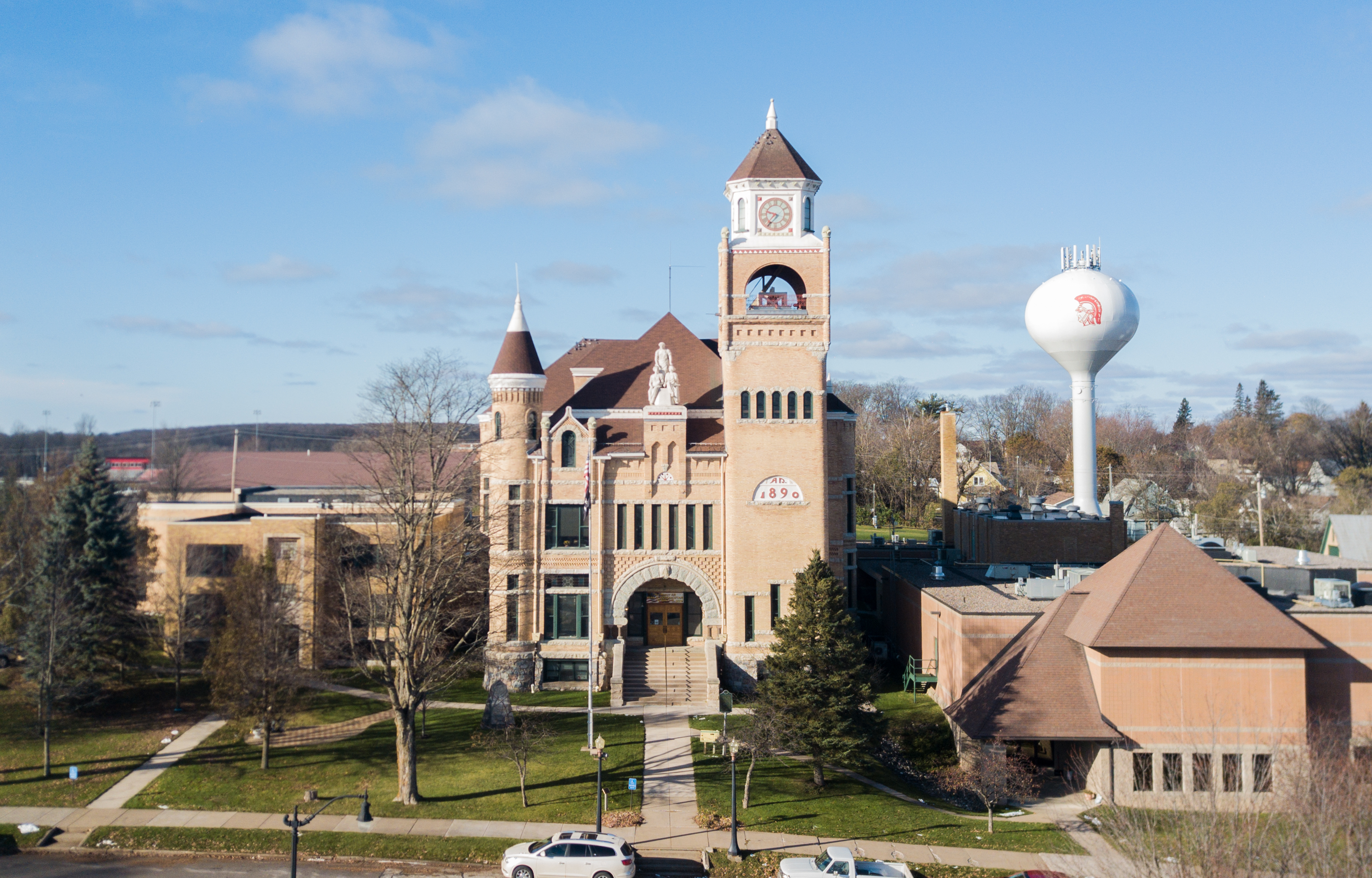 Aerial view of a historic brick courthouse with a clock tower and turrets.
