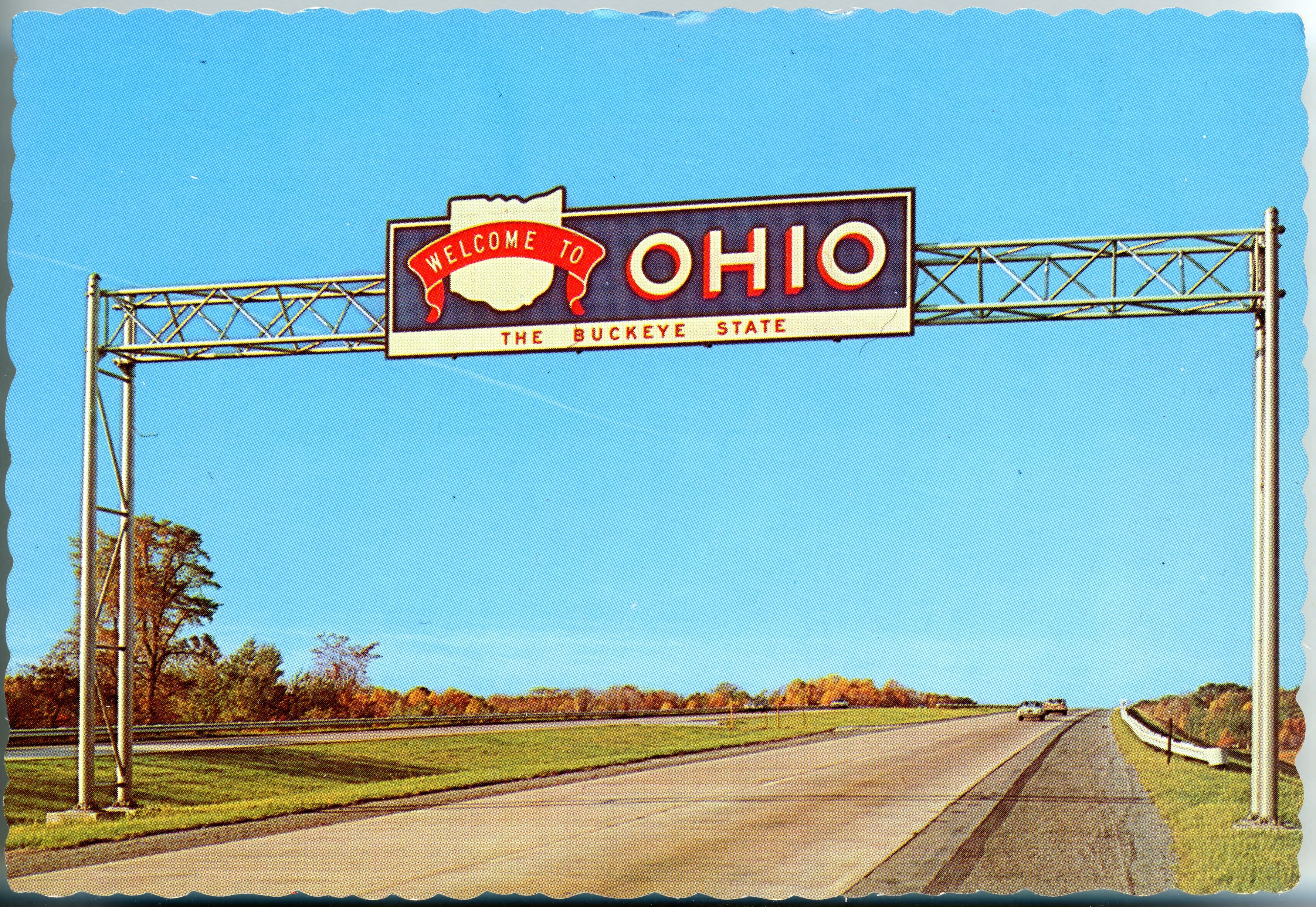 Overhead gantry sign reading 'Welcome to Ohio' spanning a multi-lane divided interstate highway.
