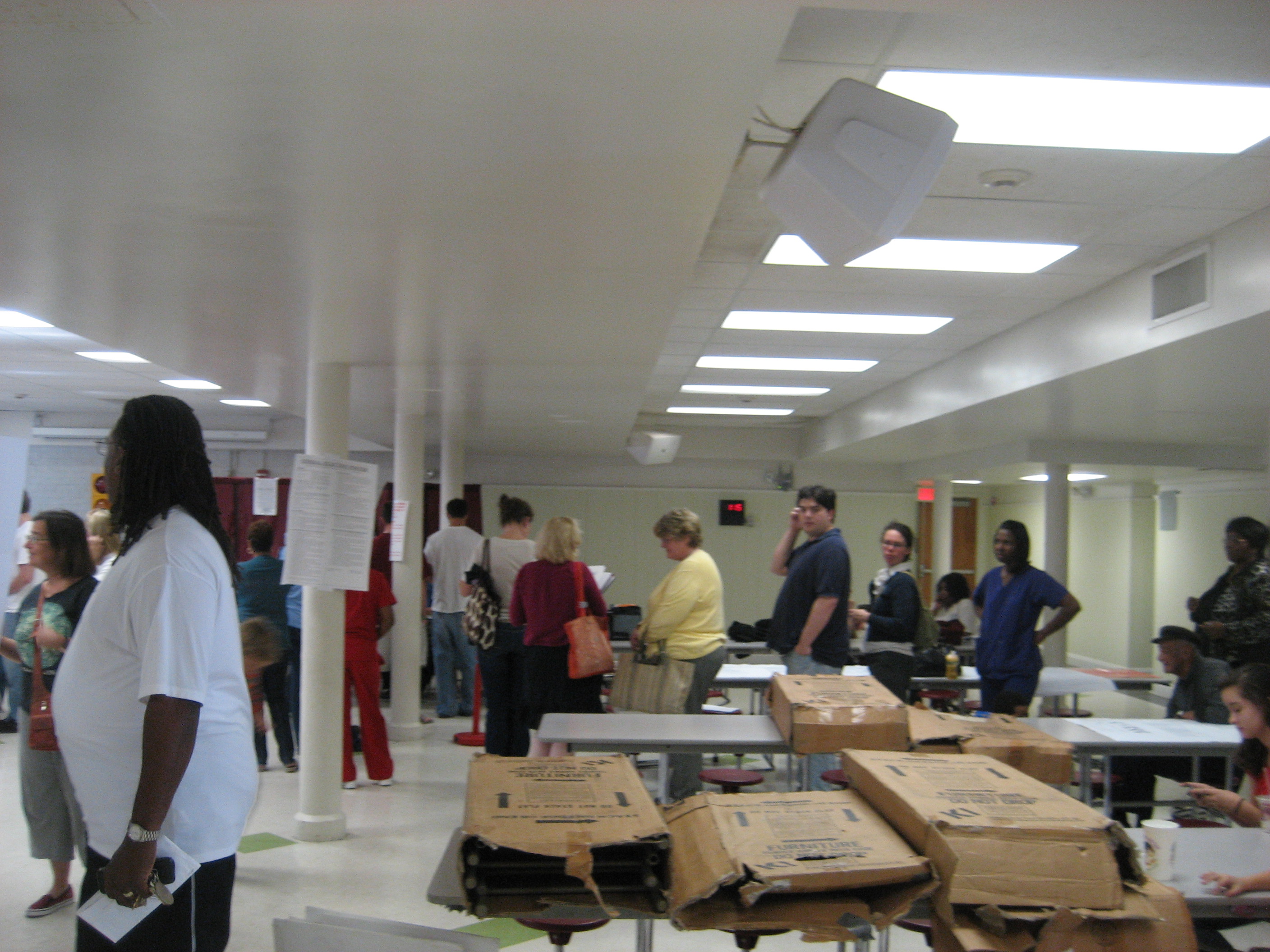 Voters standing in lines inside a crowded indoor polling location.