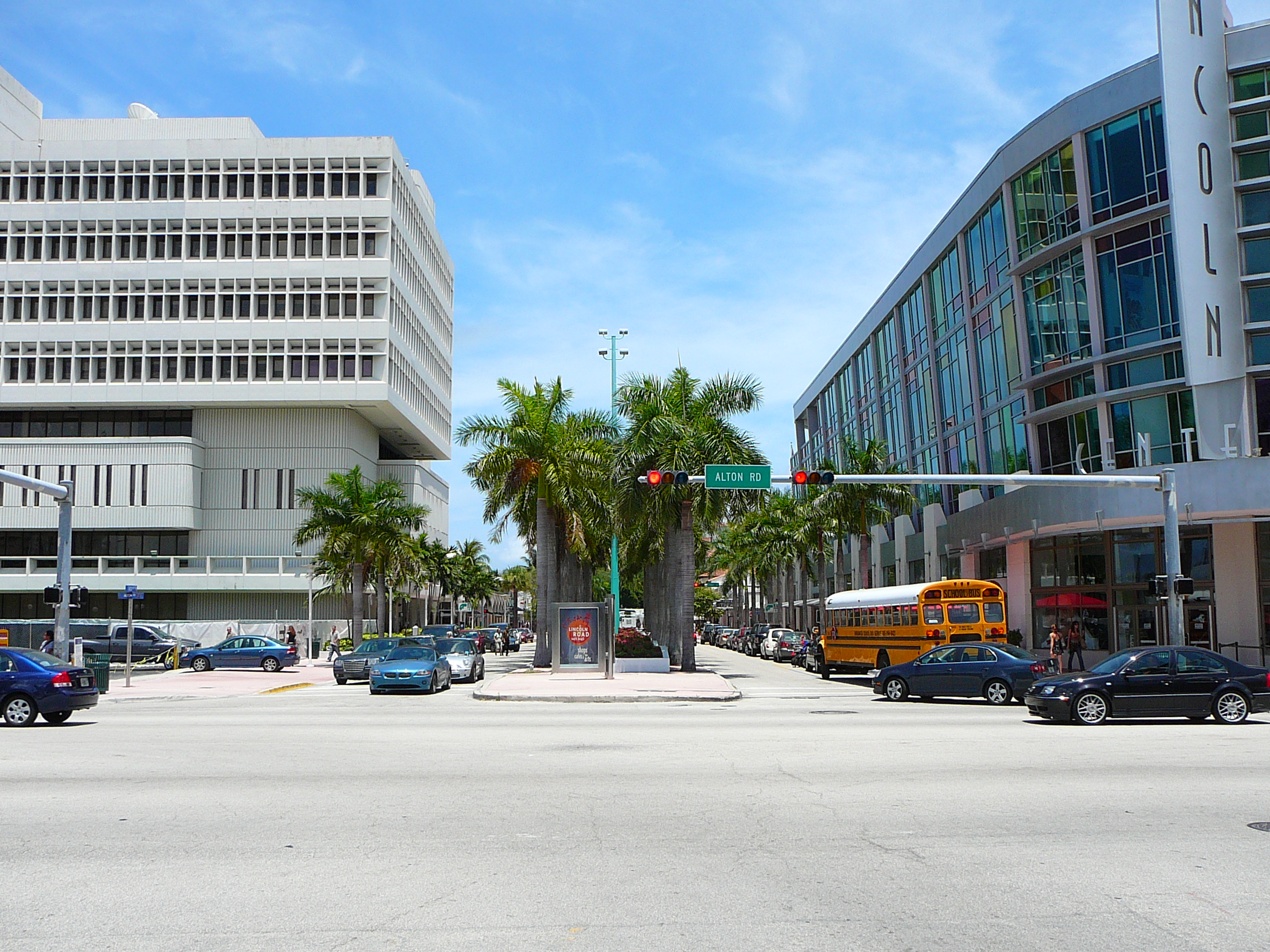 Wide street view of Lincoln Road in Miami Beach lined with palm trees and modern buildings.