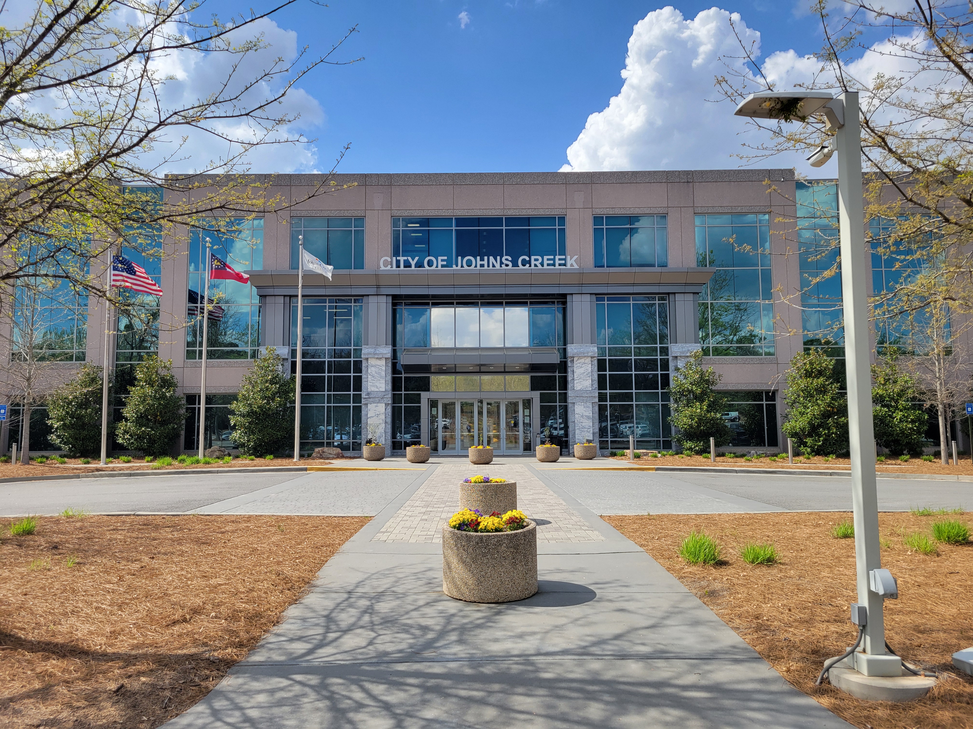 Modern government building with US and Georgia flags on flagpoles out front.