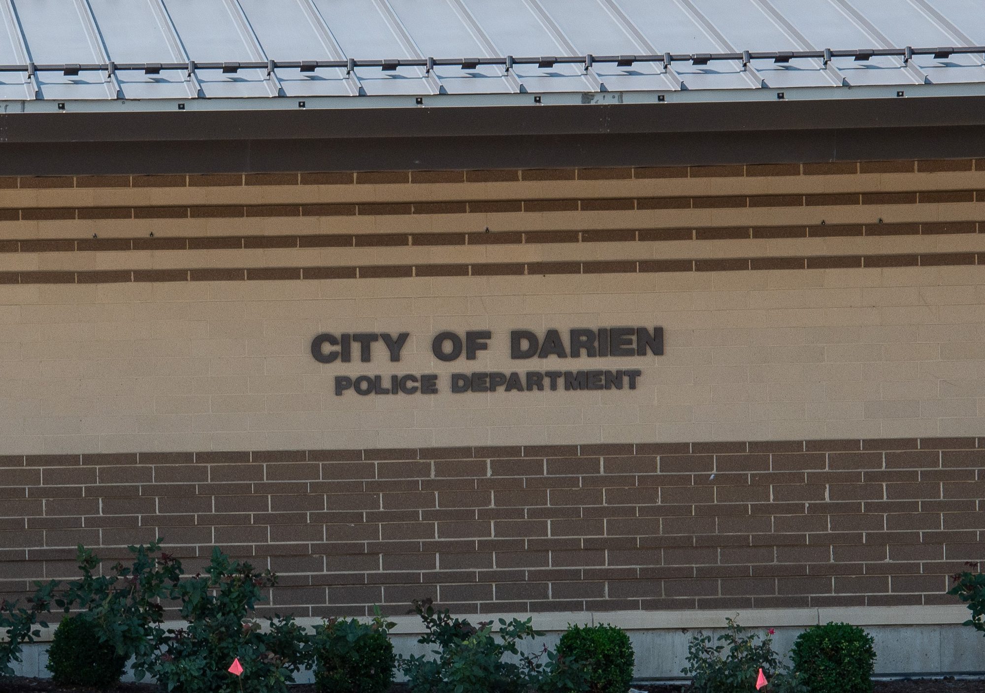 Exterior brick wall of a police department building with mounted lettering