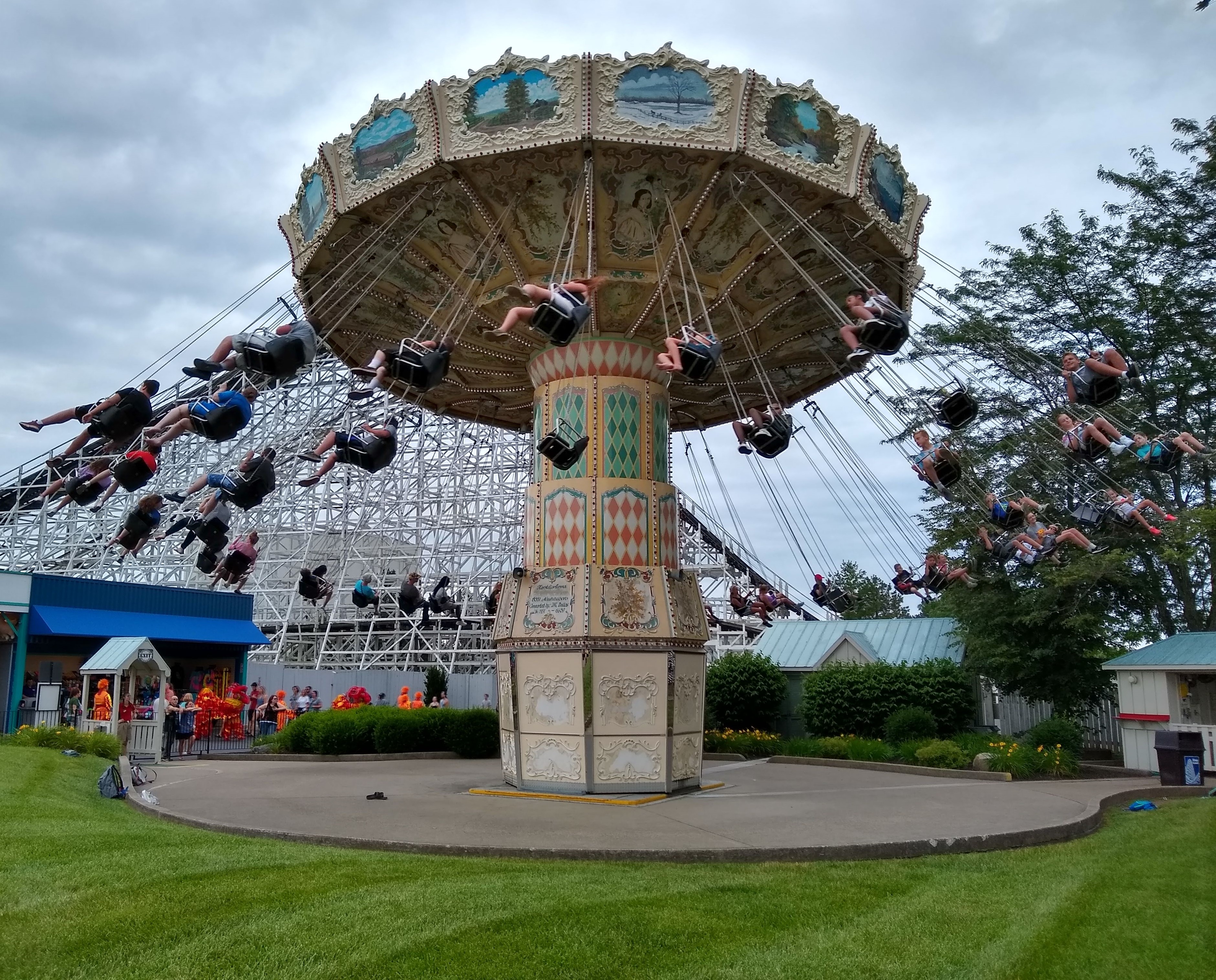 Riders swing outward on a chain swing ride at an amusement park.