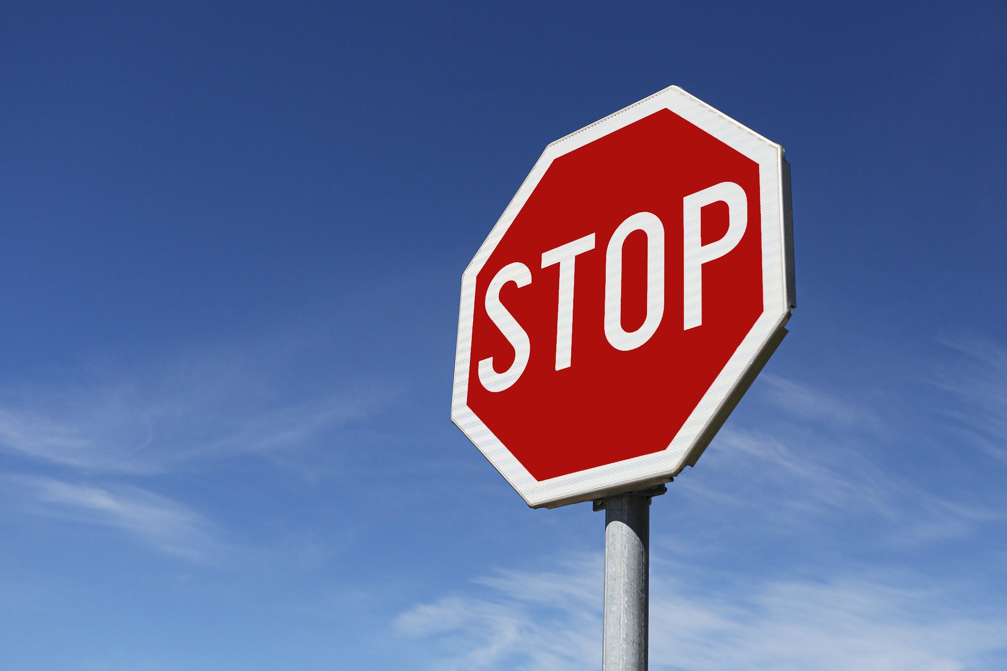 Stop traffic sign against blue sky. Road safety symbol with red octagon sign clear background
