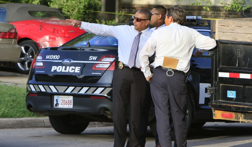 Three plainclothes detectives stand near a marked Oklahoma City Police patrol car.