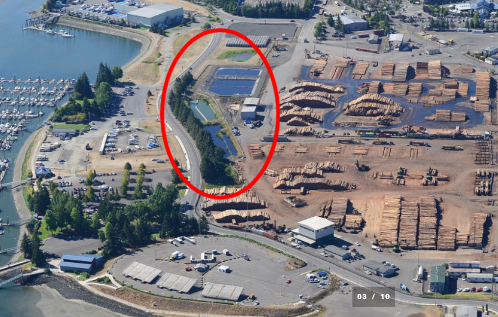 Aerial view of an industrial port area with stormwater retention ponds circled in red.
