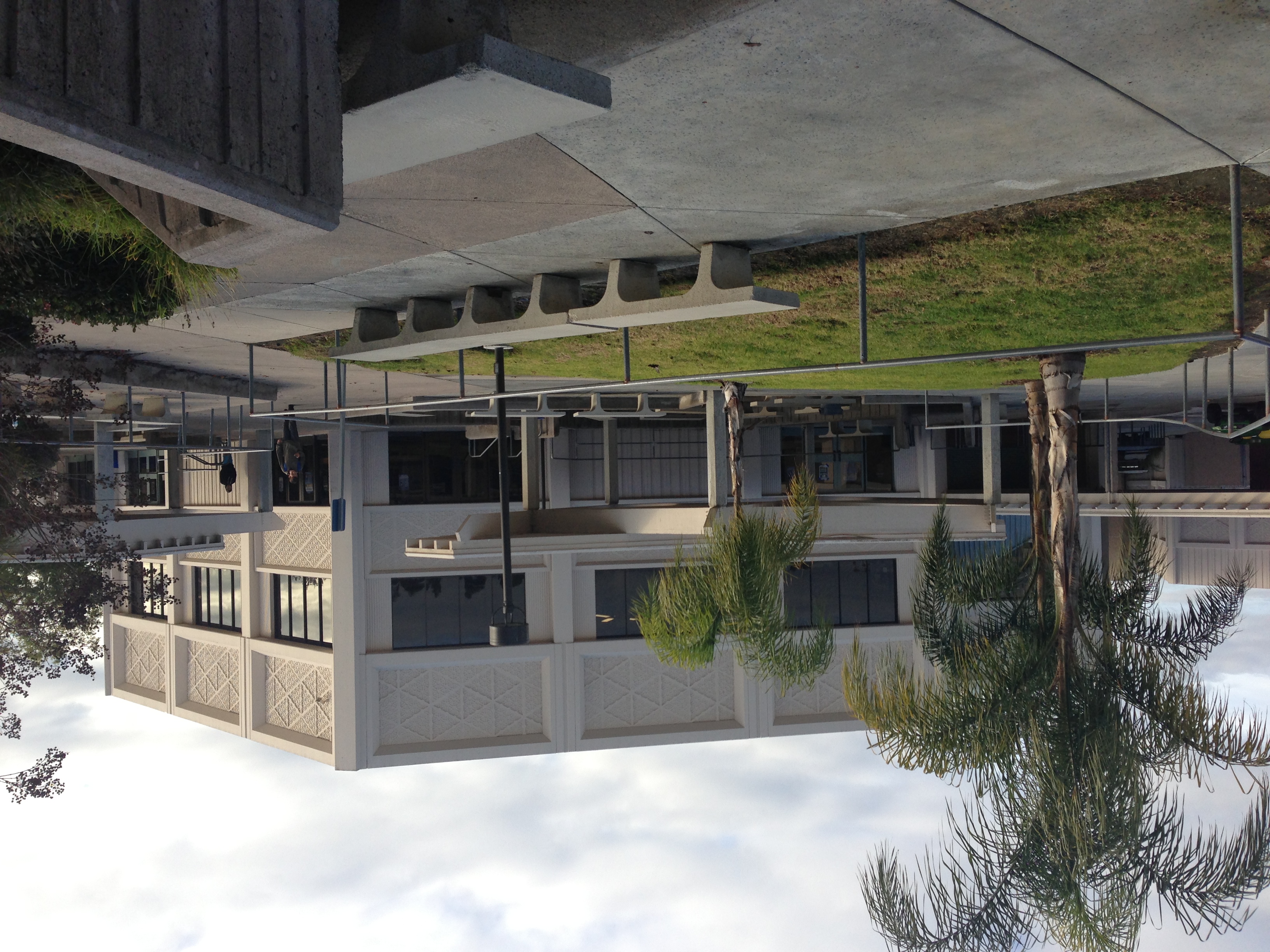 Two-story school building with palm trees and a courtyard on a California campus.