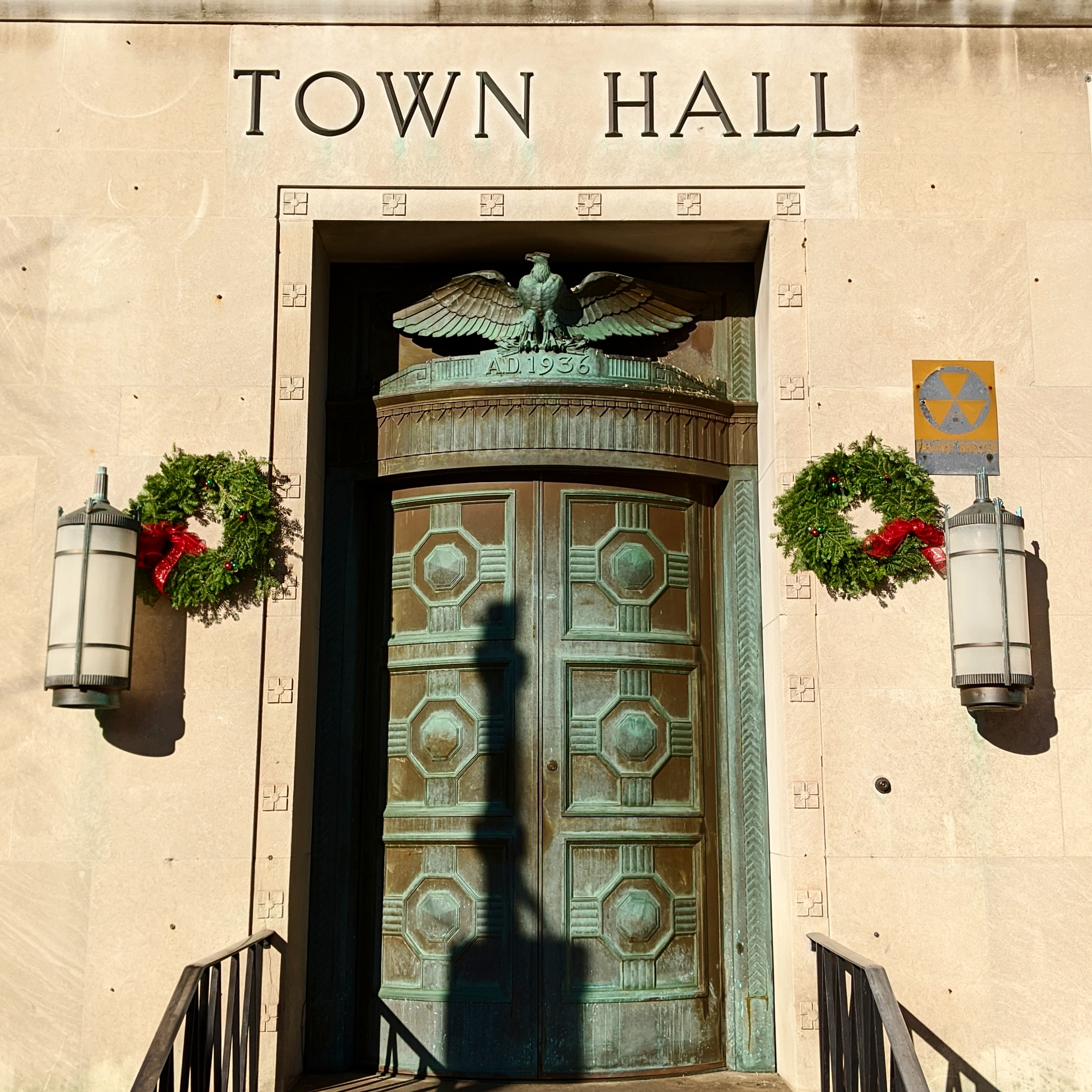 Ornate bronze entrance doors of a building labeled Town Hall, with an eagle above.