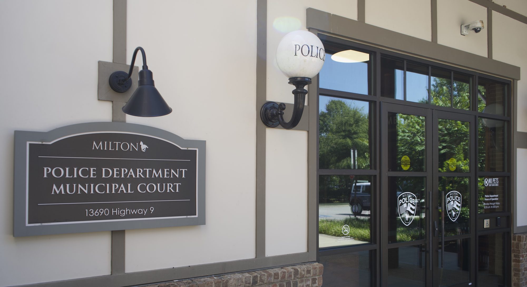 Exterior entrance of a police department building with a globe light fixture labeled Police.