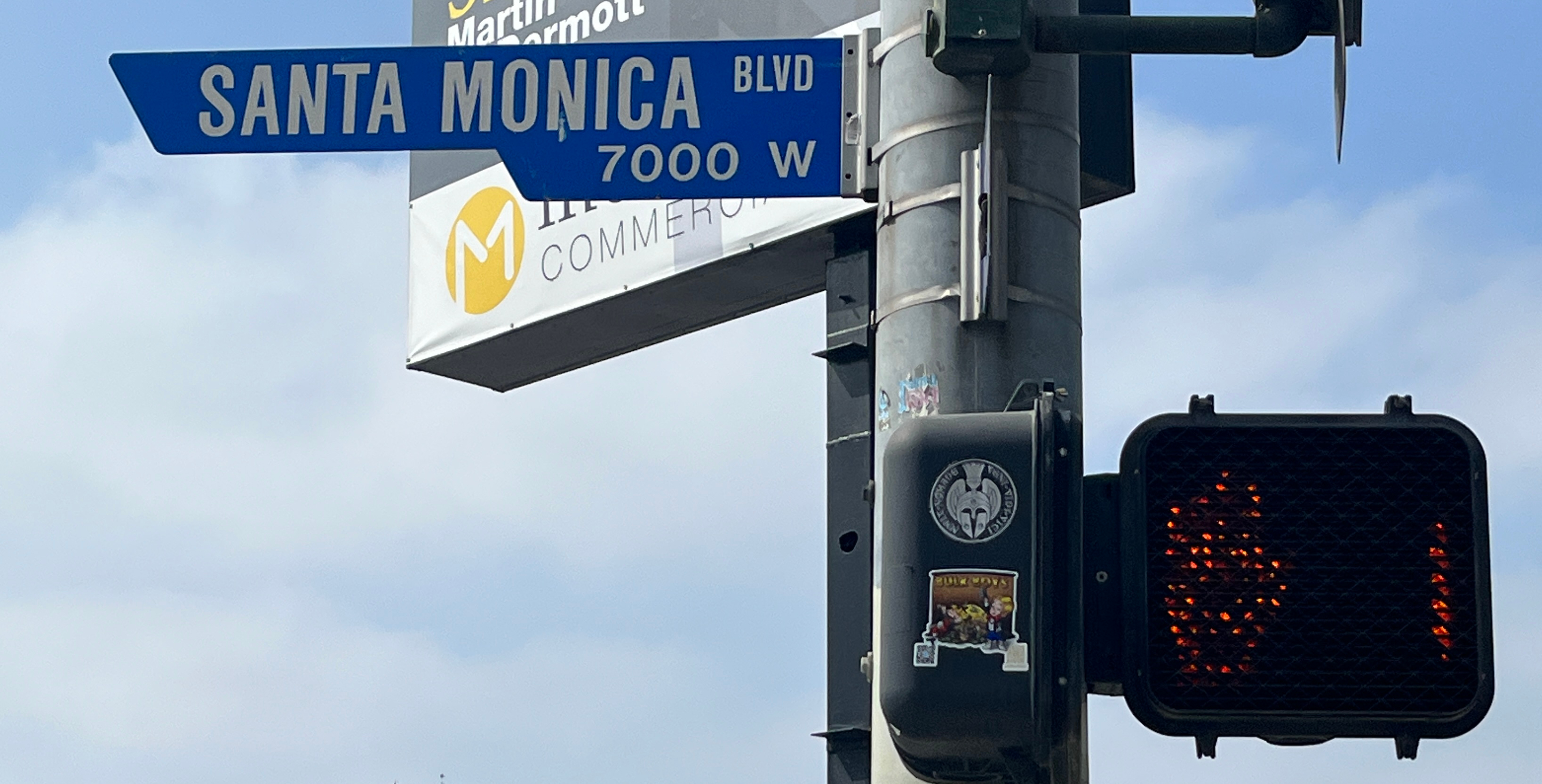 Blue street sign reading Santa Monica Blvd mounted on a pole.