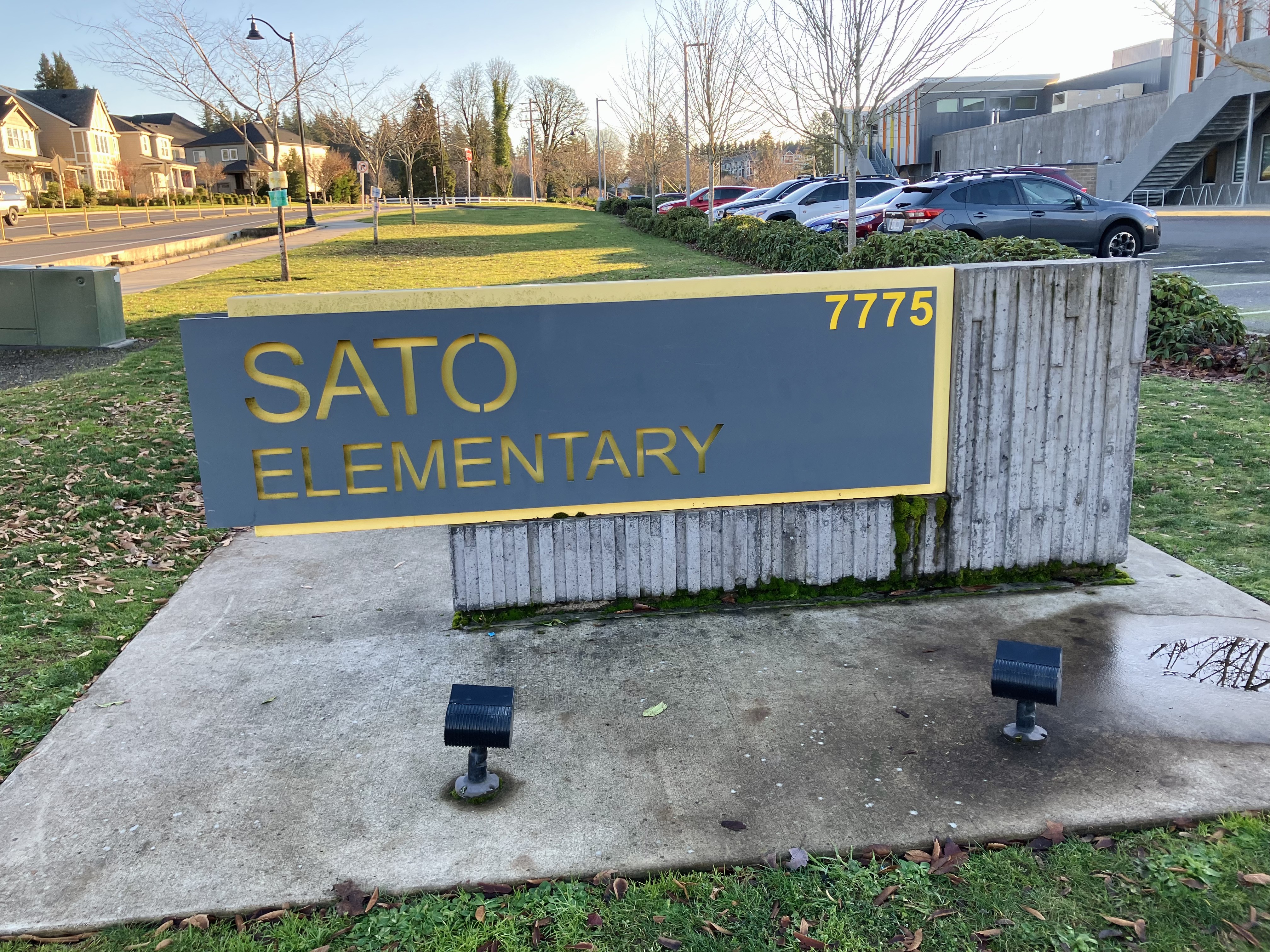 Monument sign reading 'Sato Elementary' outside a modern school building.