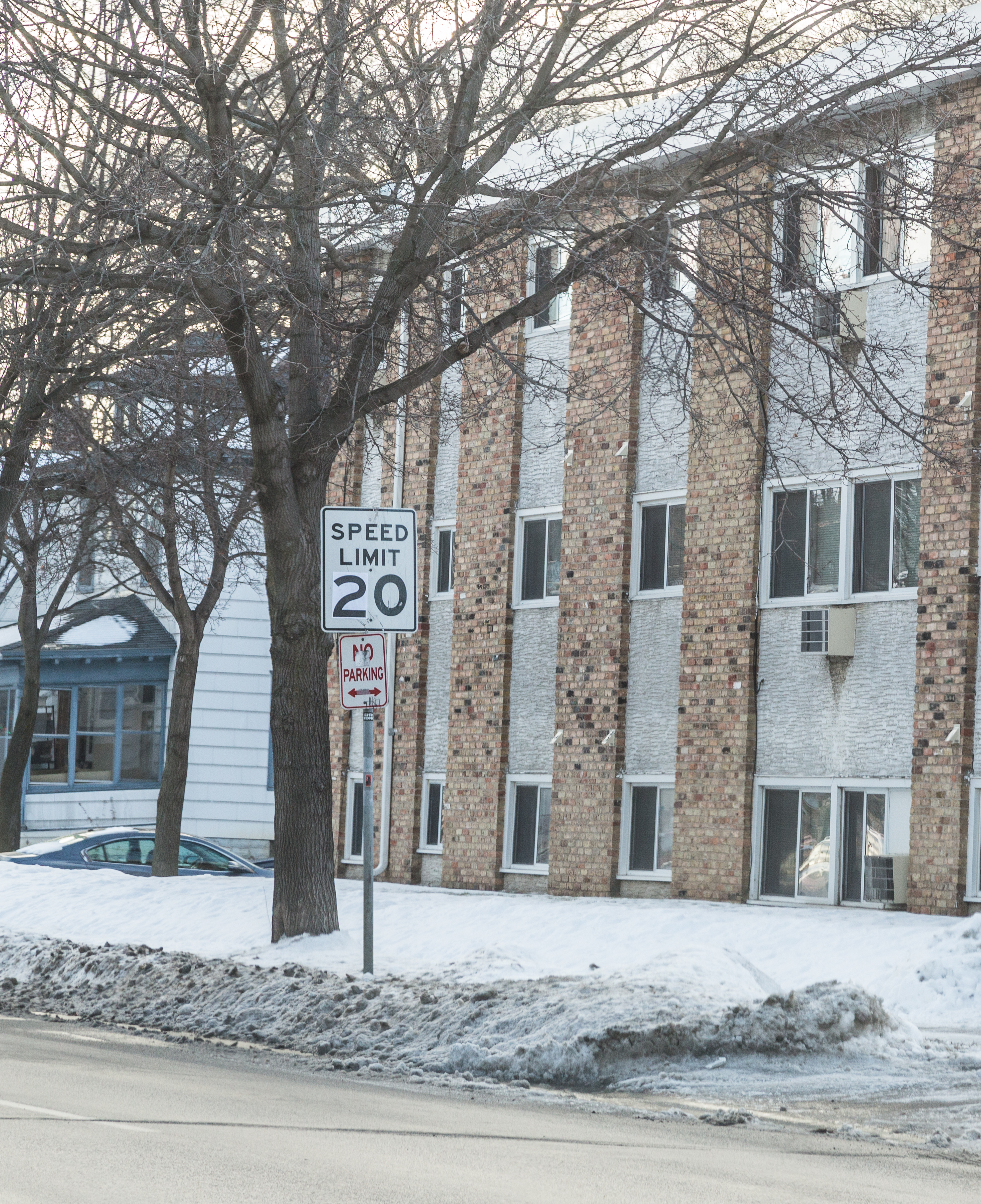 A 20 mph speed limit sign mounted on a pole on a residential street.
