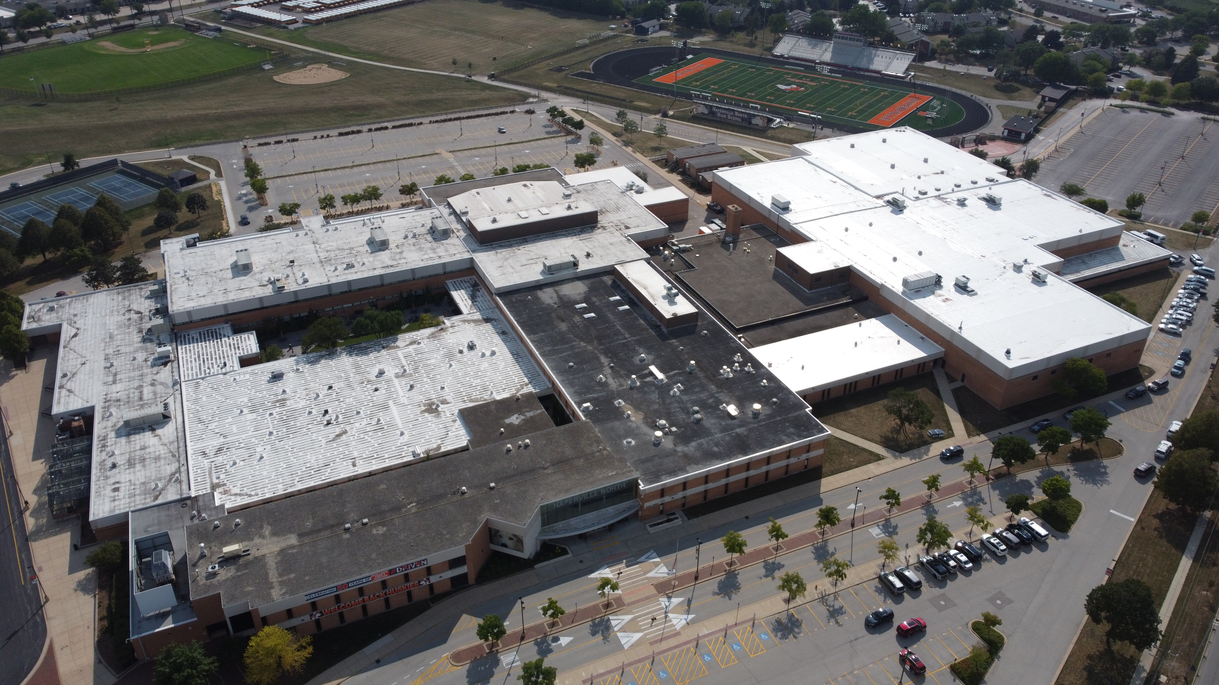 Aerial view of a large suburban high school campus with athletic fields and parking lots.
