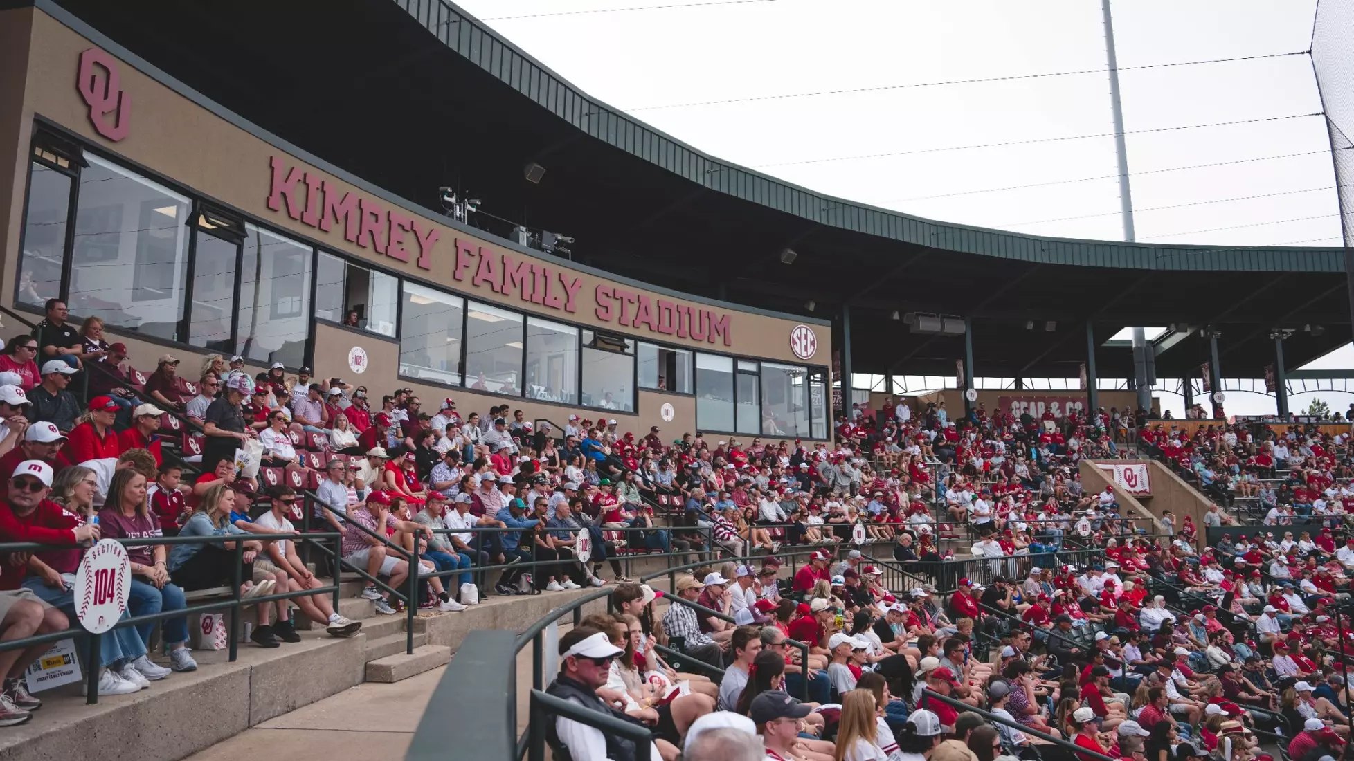 Packed stadium grandstand with fans in red beneath a sign reading Kimrey Family Stadium.