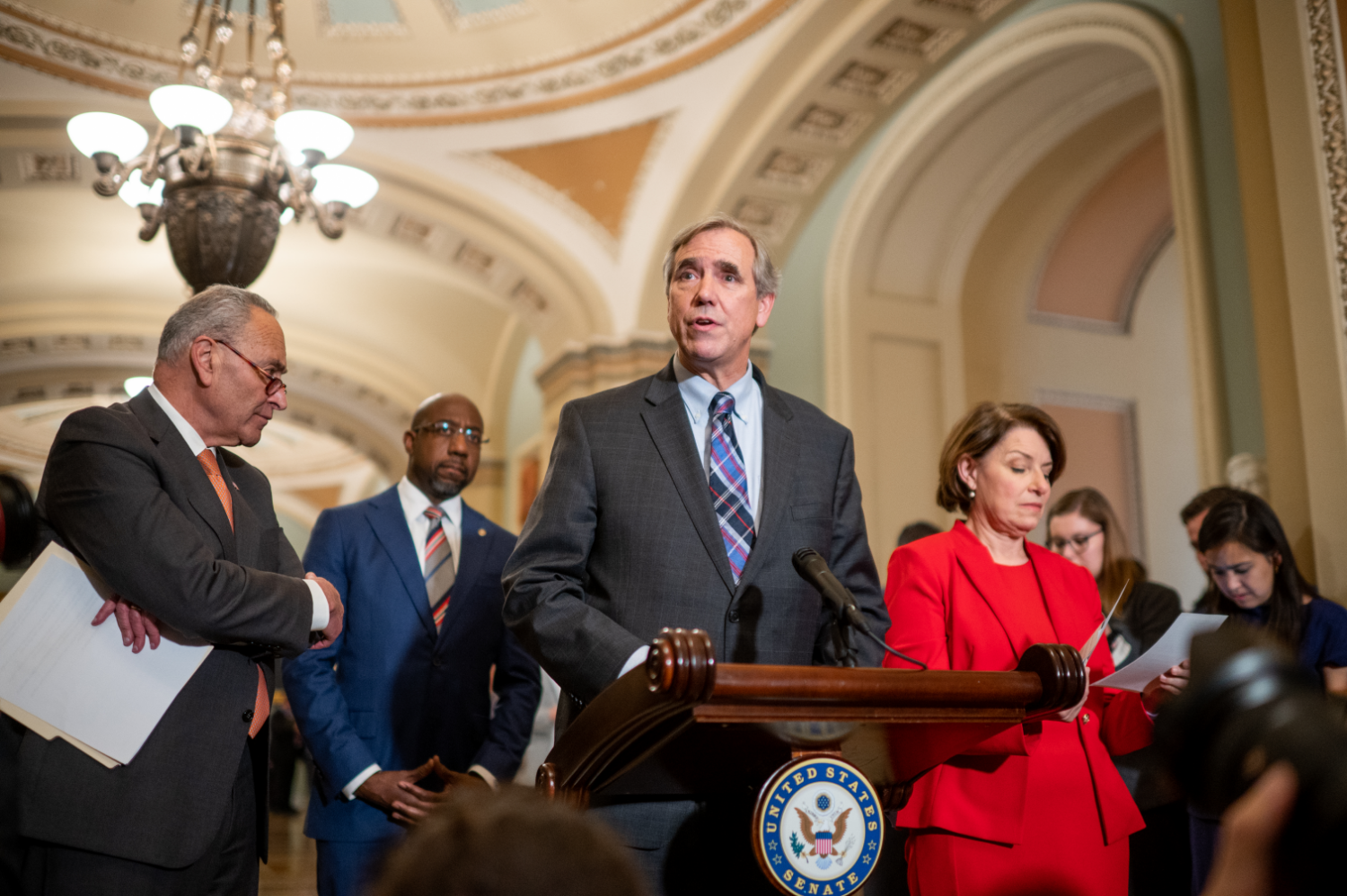 US Senator Jeff Merkley in the Capitol, behind podium 