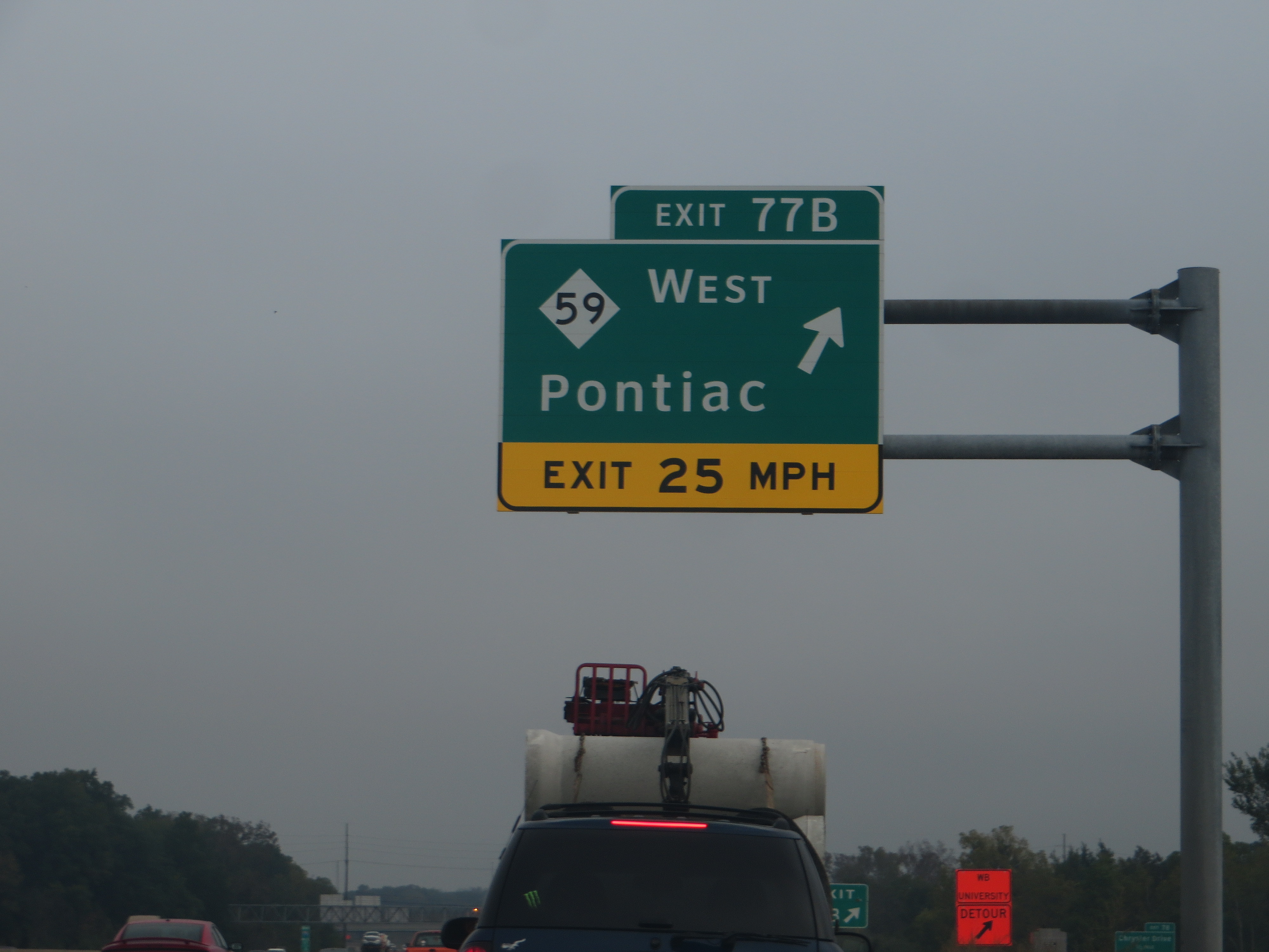 Green overhead highway exit sign for M-59 West toward Pontiac on a multi-lane freeway.