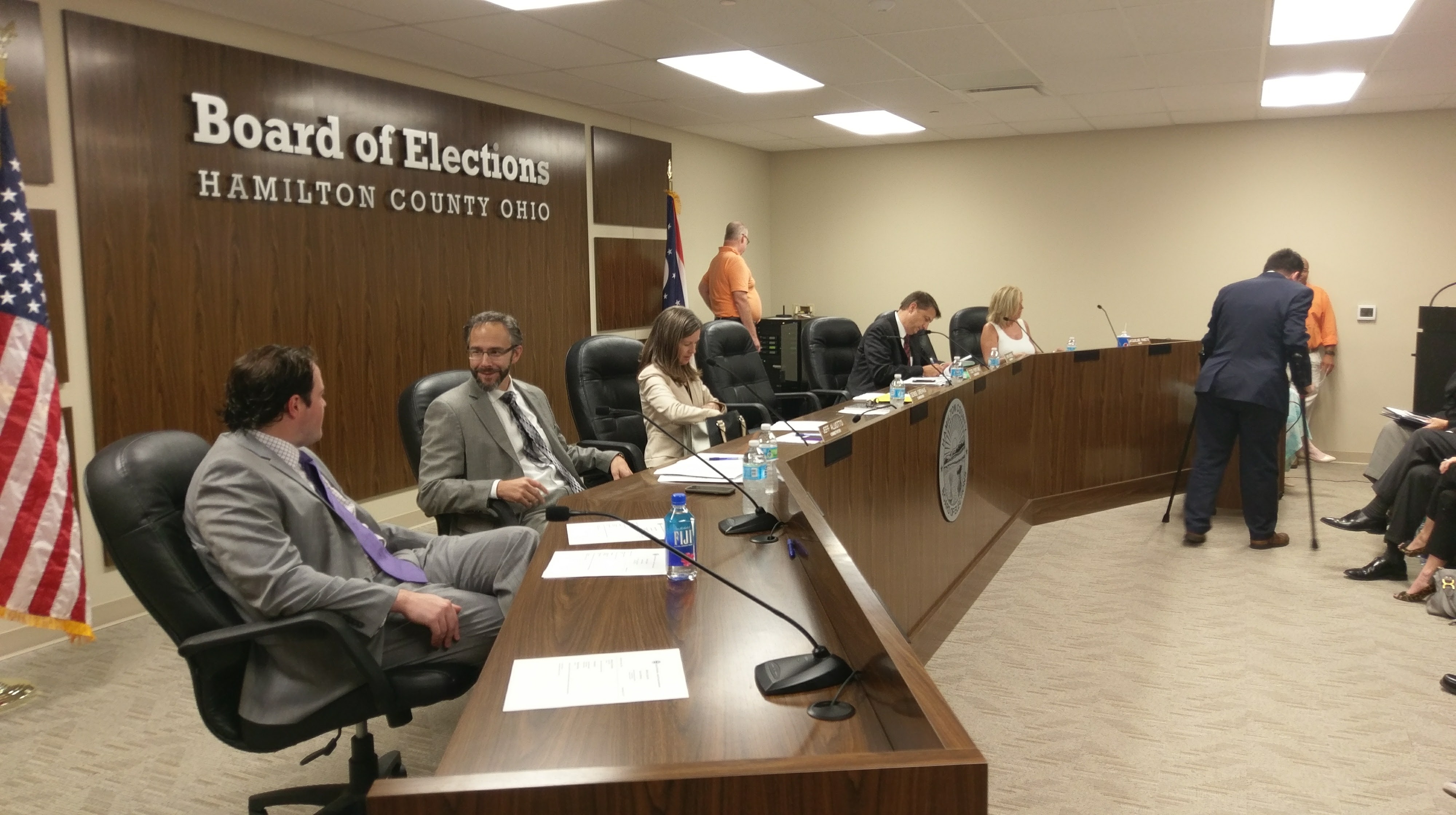Officials seated at a conference table inside a room with a Board of Elections Hamilton County Ohio sign on the wall.