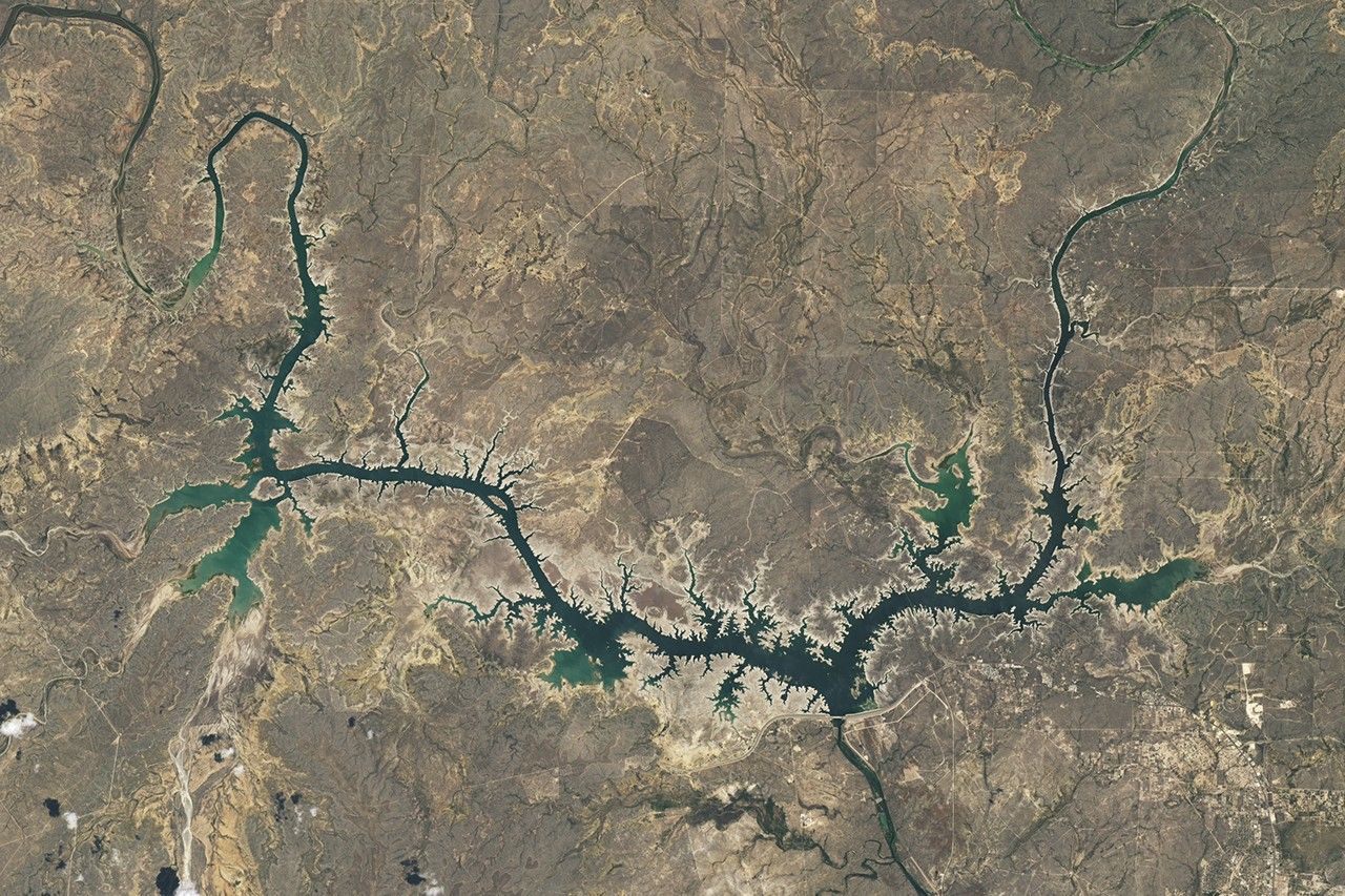 Satellite image of a reservoir with very low water and wide dry exposed banks