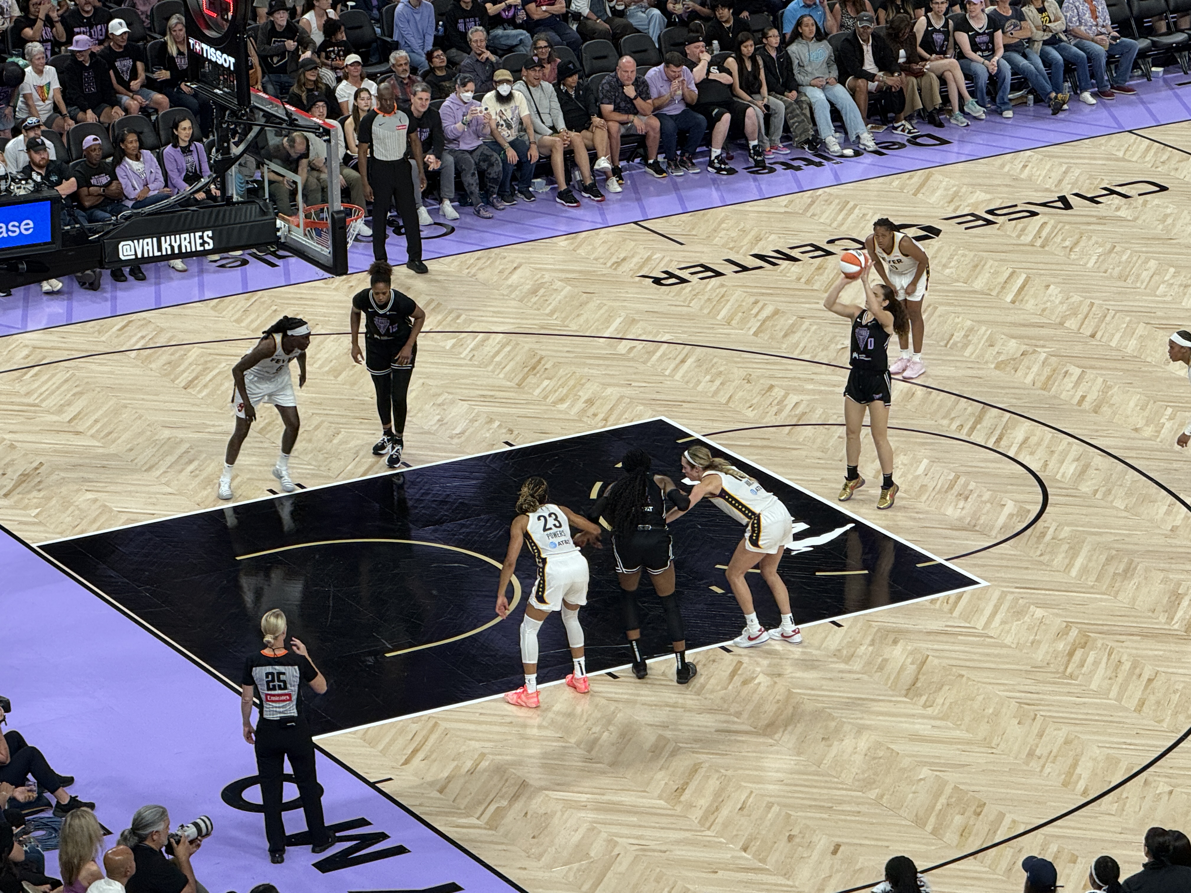 Basketball players from two teams compete on the hardwood court inside Chase Center.