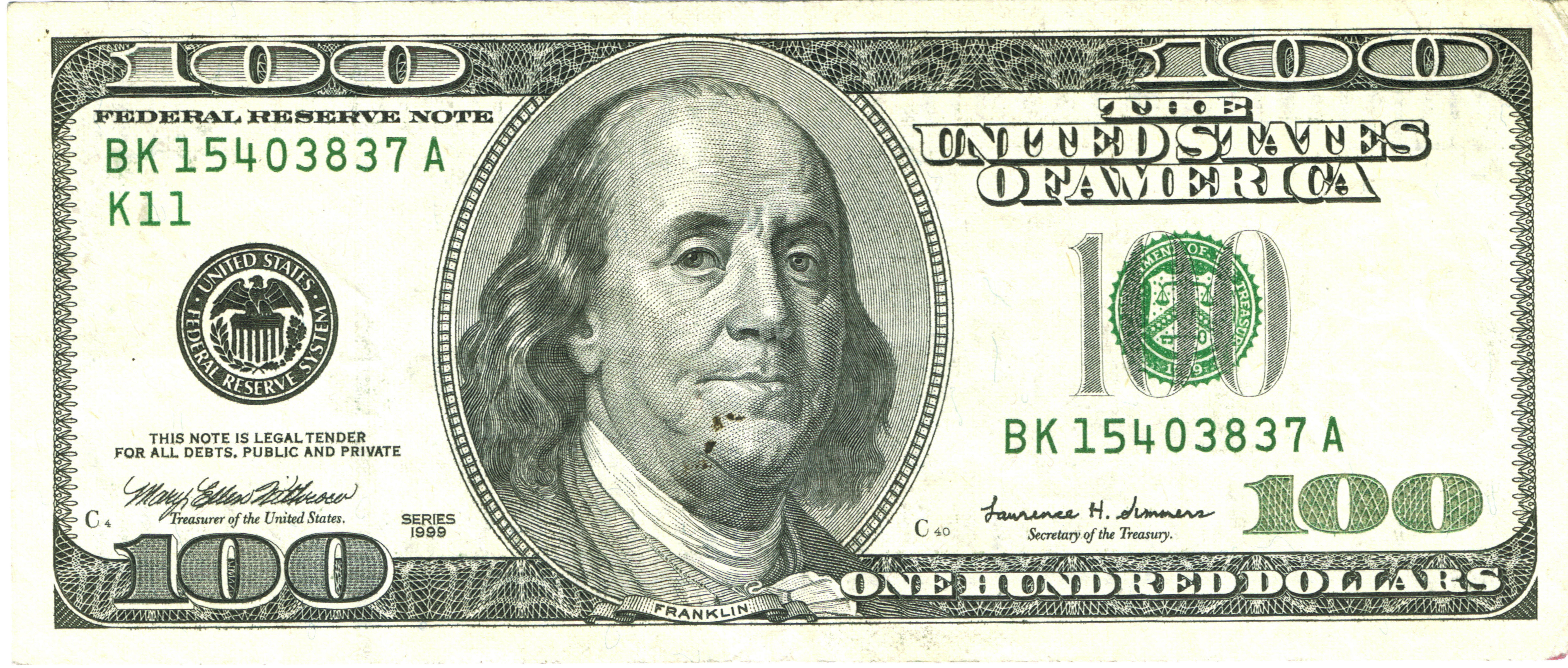 A U.S. hundred-dollar bill face-up, showing Benjamin Franklin's portrait.
