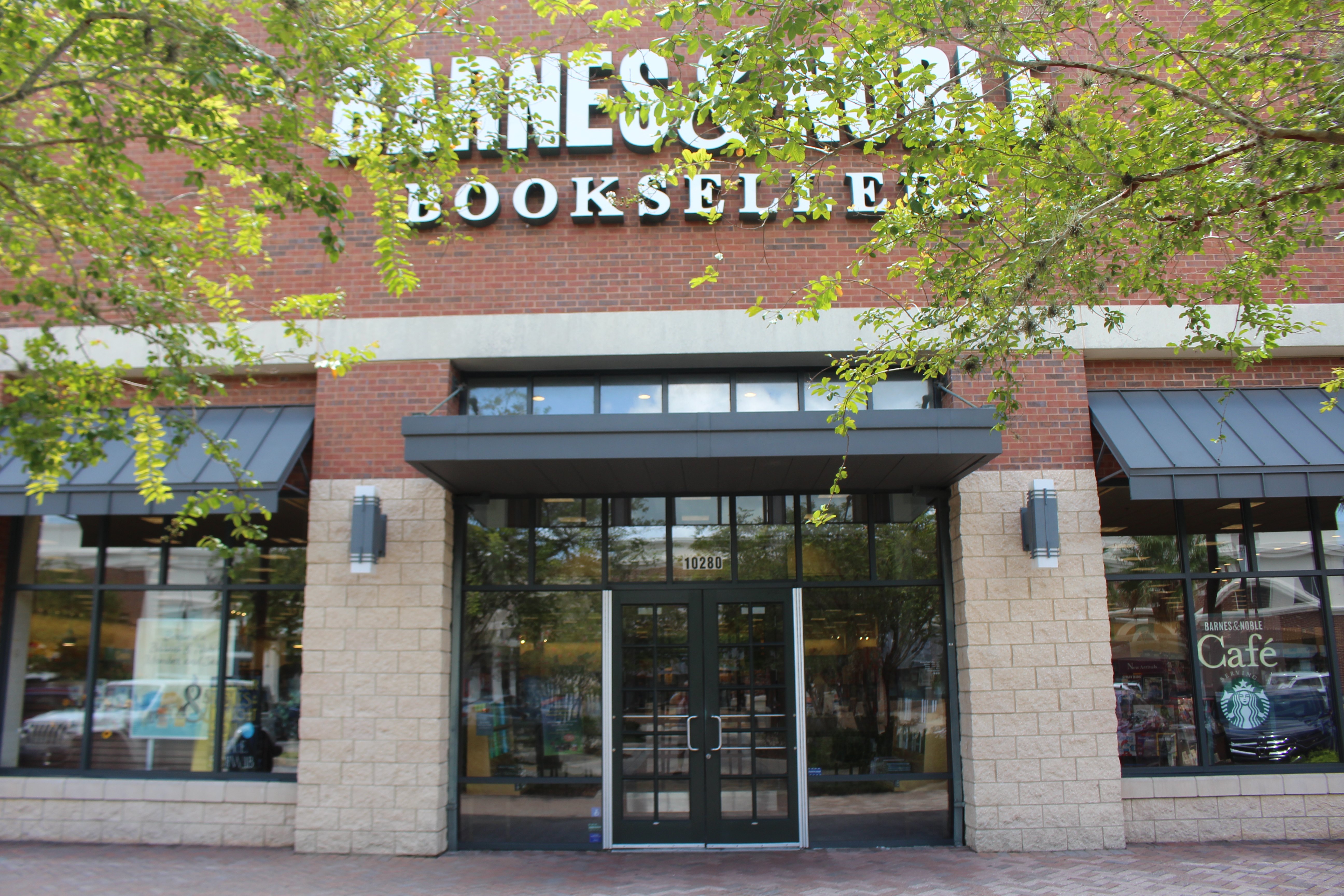 Brick retail storefront with dark awnings at St. Johns Town Center in Jacksonville.