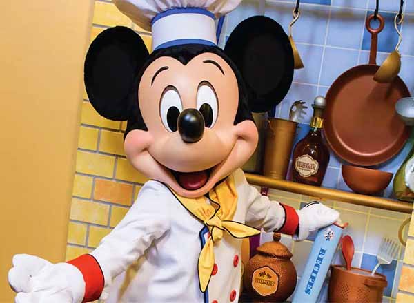 Mickey Mouse character costume dressed in a white chef's coat and tall chef's hat.