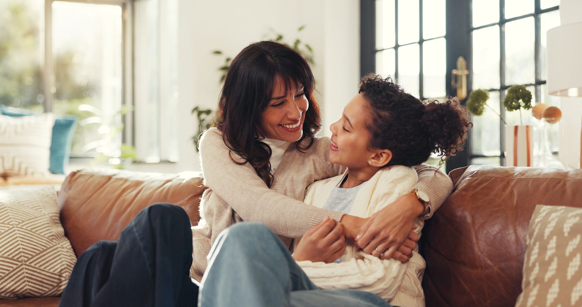 Happy, hug and mom with girl on sofa for bonding, relationship and support in living room. Family, parenting and mother with child embrace on couch for affection, care and love in home on weekend