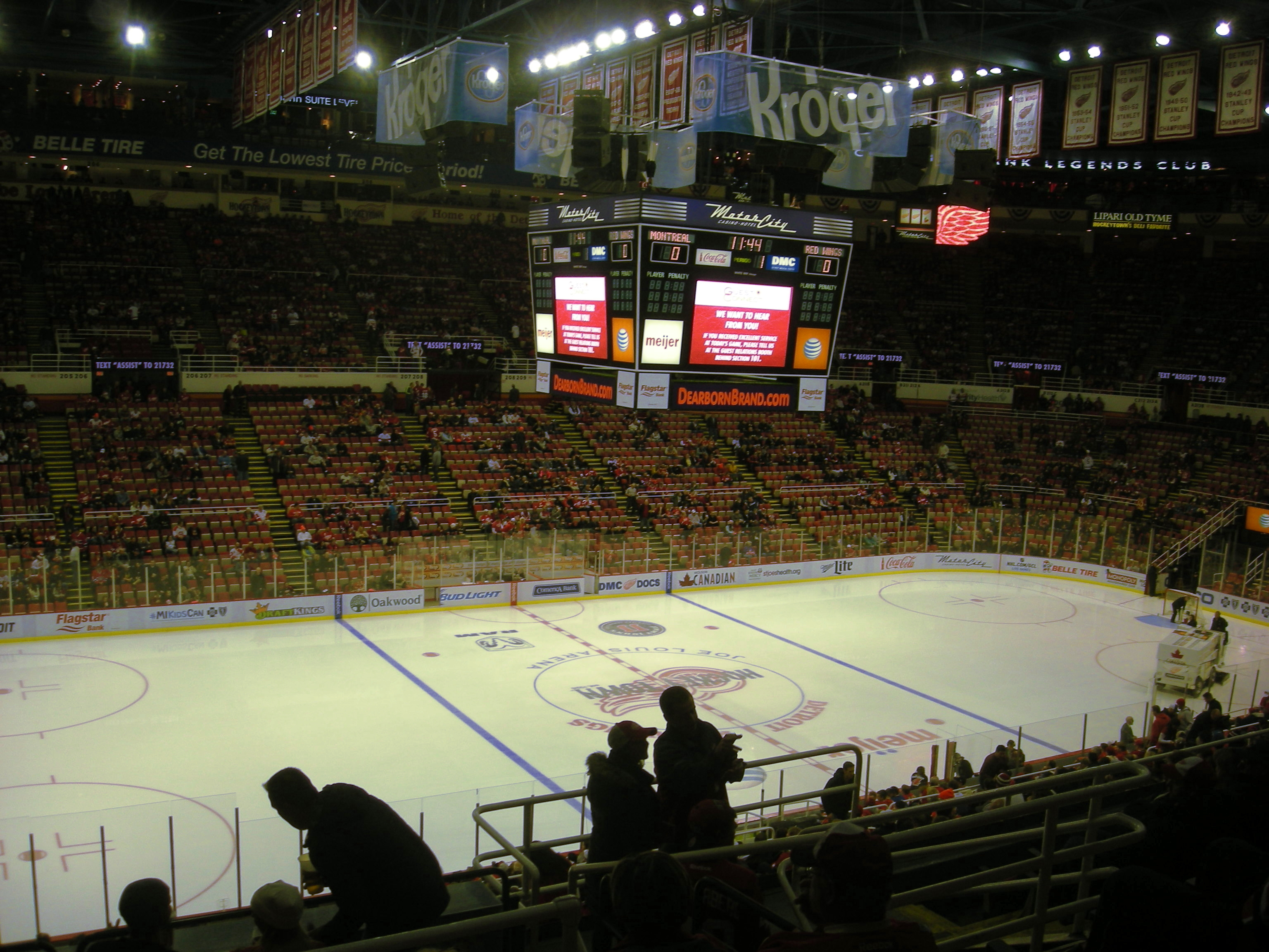Interior of an indoor ice hockey arena with a freshly resurfaced rink and filled stands.