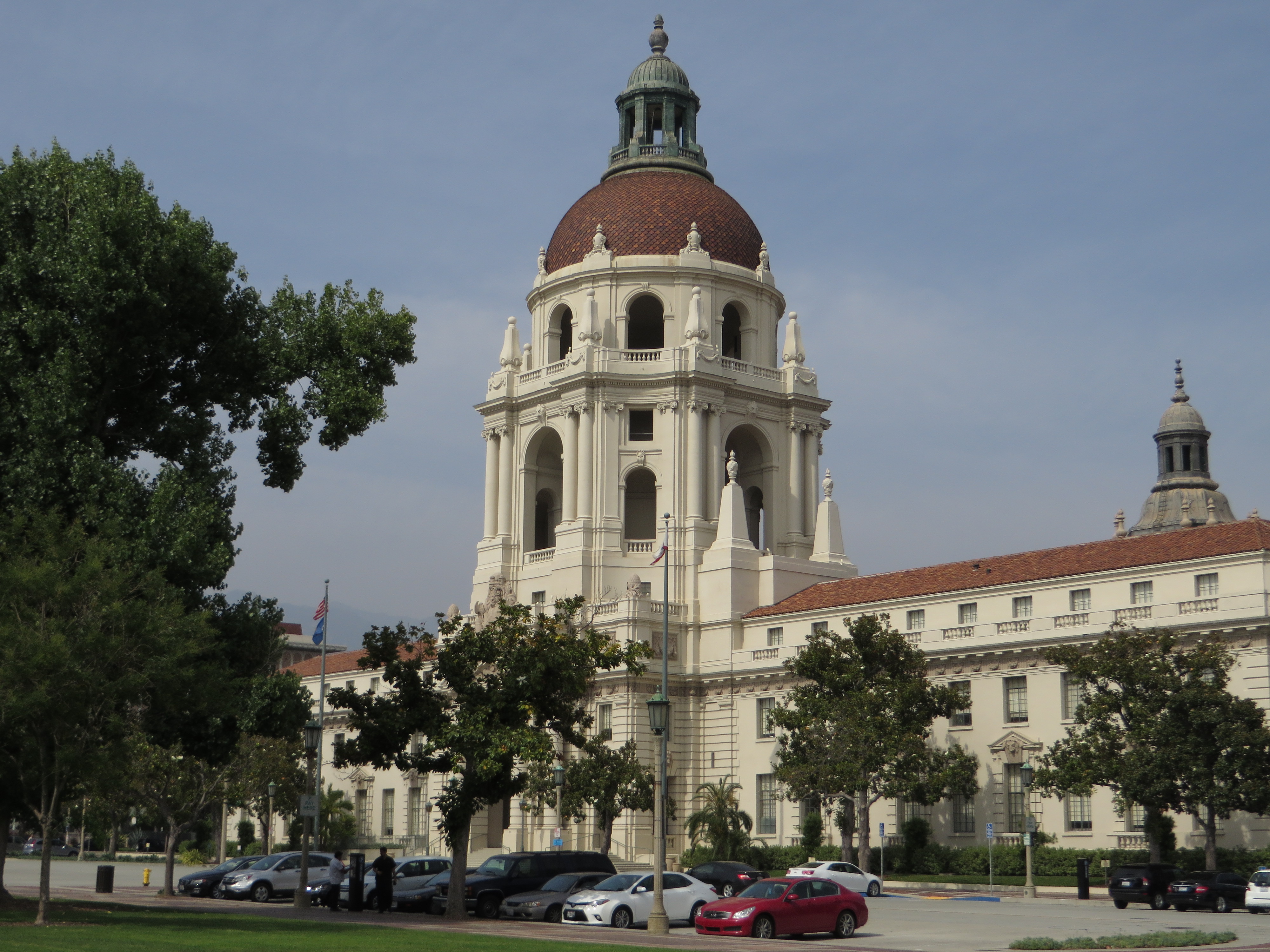 Pasadena City Hall exterior with its large dome, red-tiled roof, and surrounding trees.