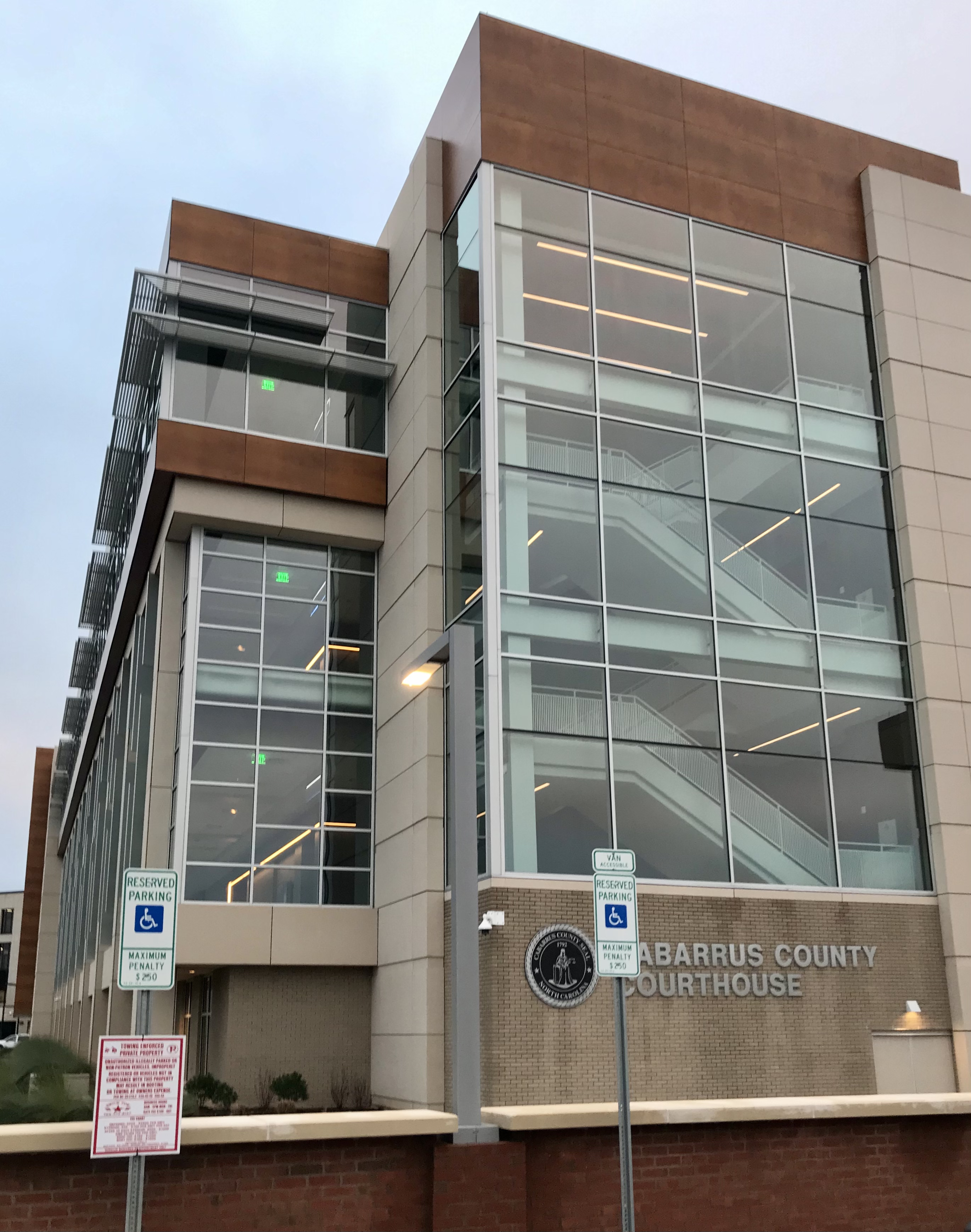 Modern glass and stone courthouse building with a sign reading Cabarrus County Courthouse.