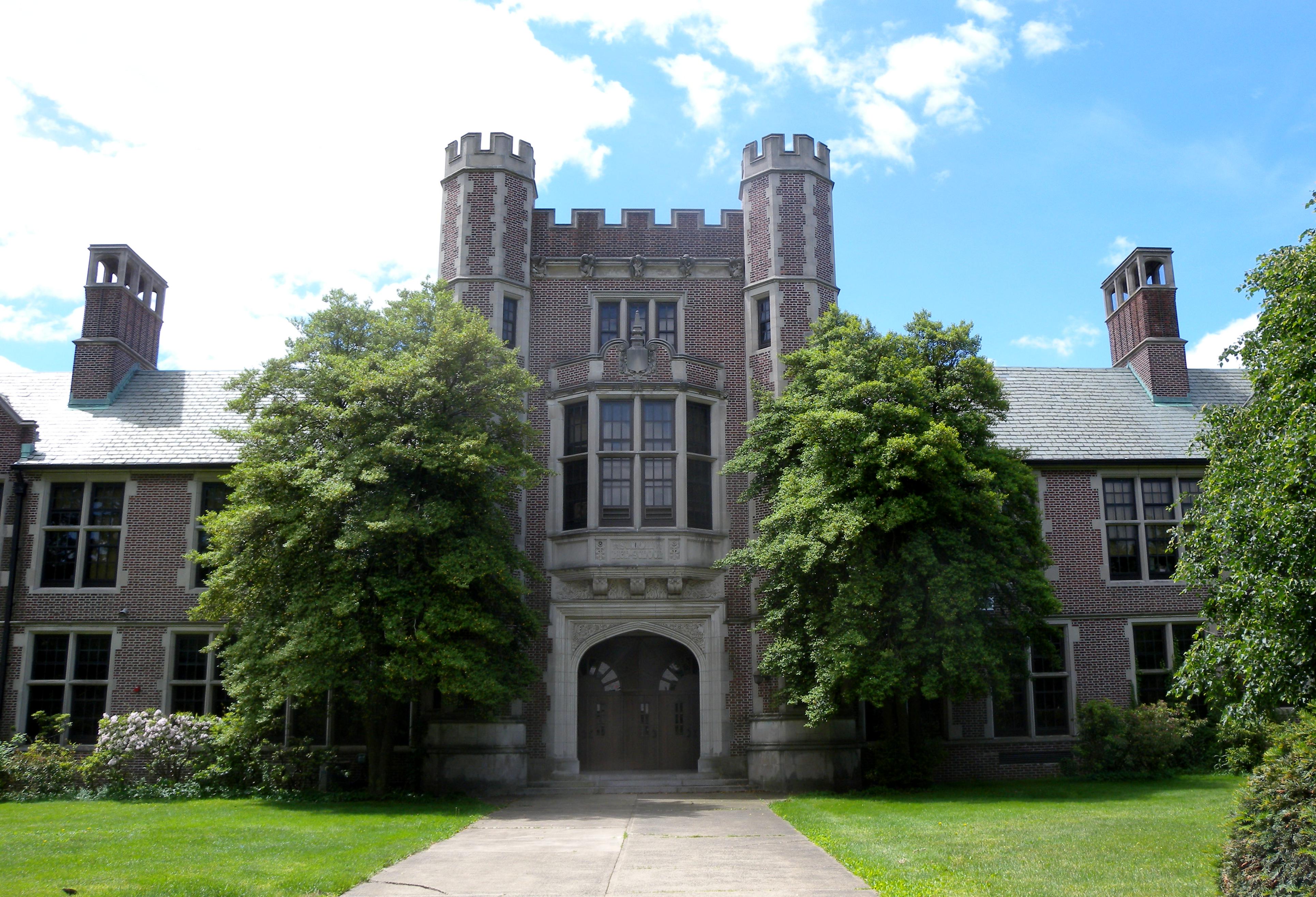 Gothic-style brick school building with crenellated towers and an arched entrance.