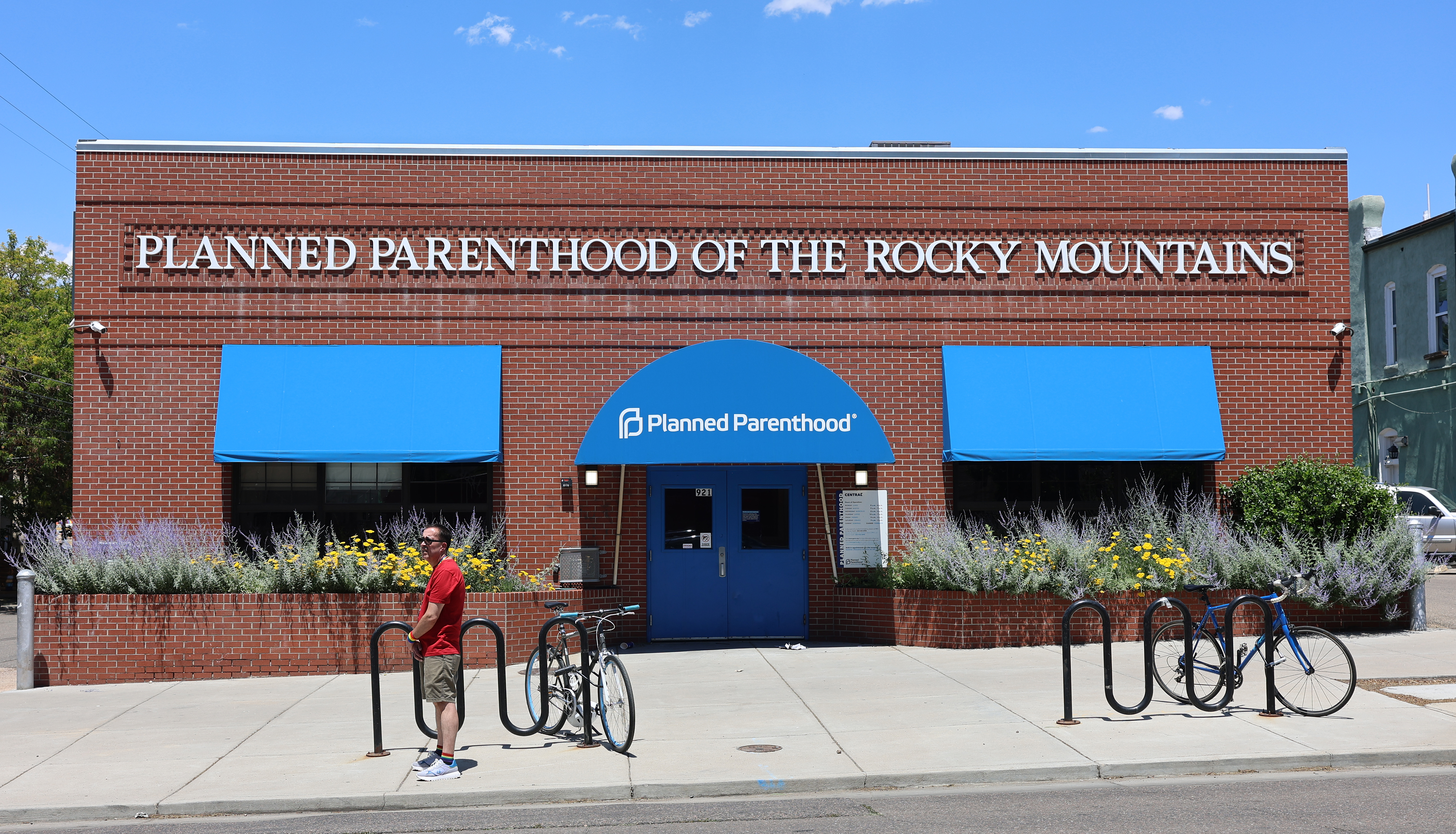 Brick Planned Parenthood clinic building with blue awnings and signage.