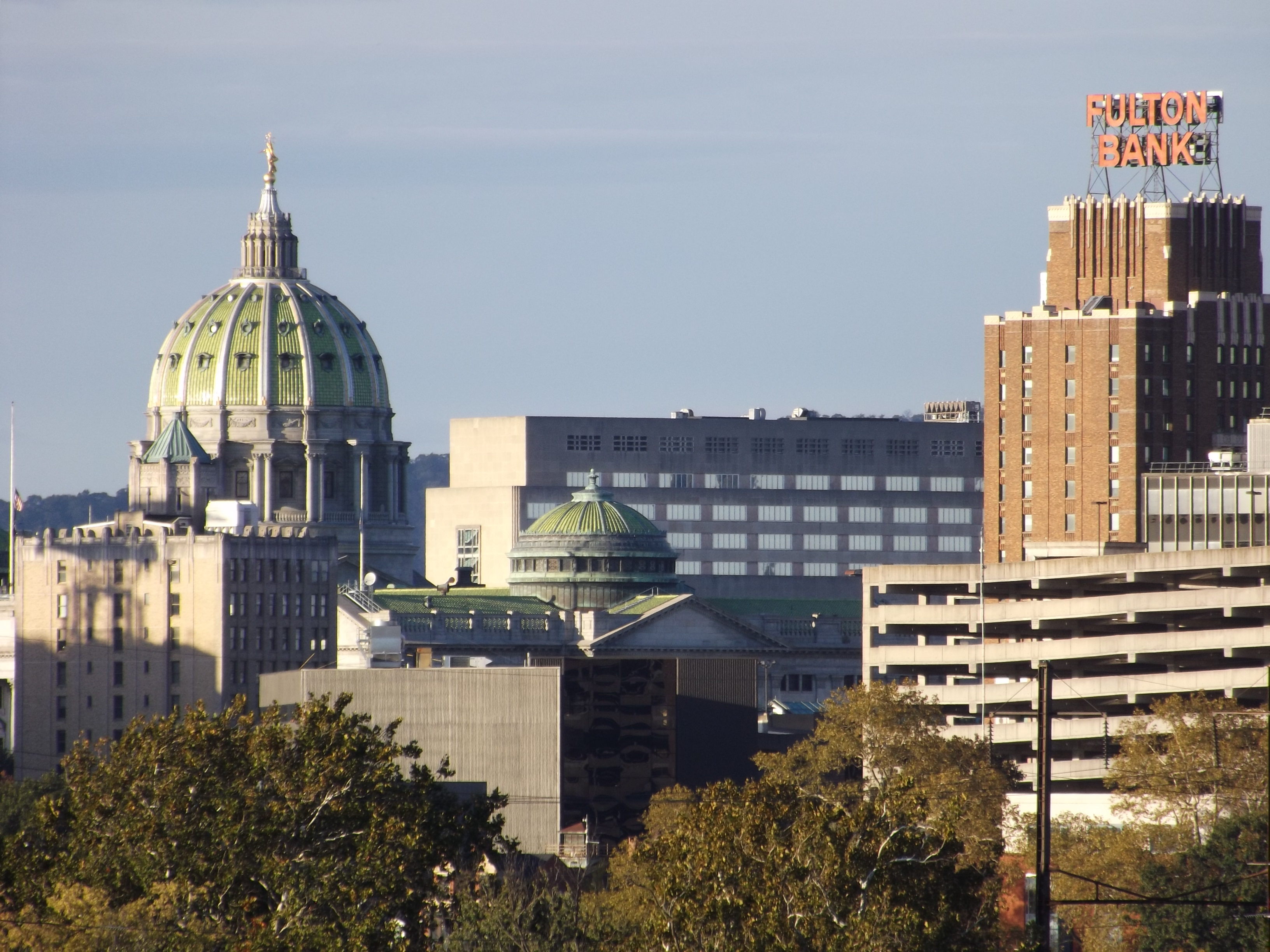Harrisburg skyline with the Pennsylvania State Capitol dome visible among trees.