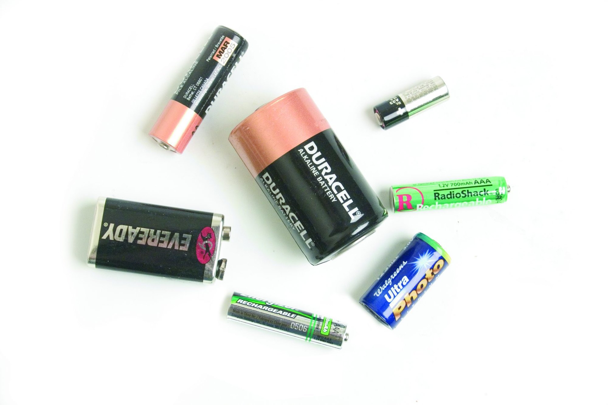 Assorted household batteries of various sizes arranged on a white background.