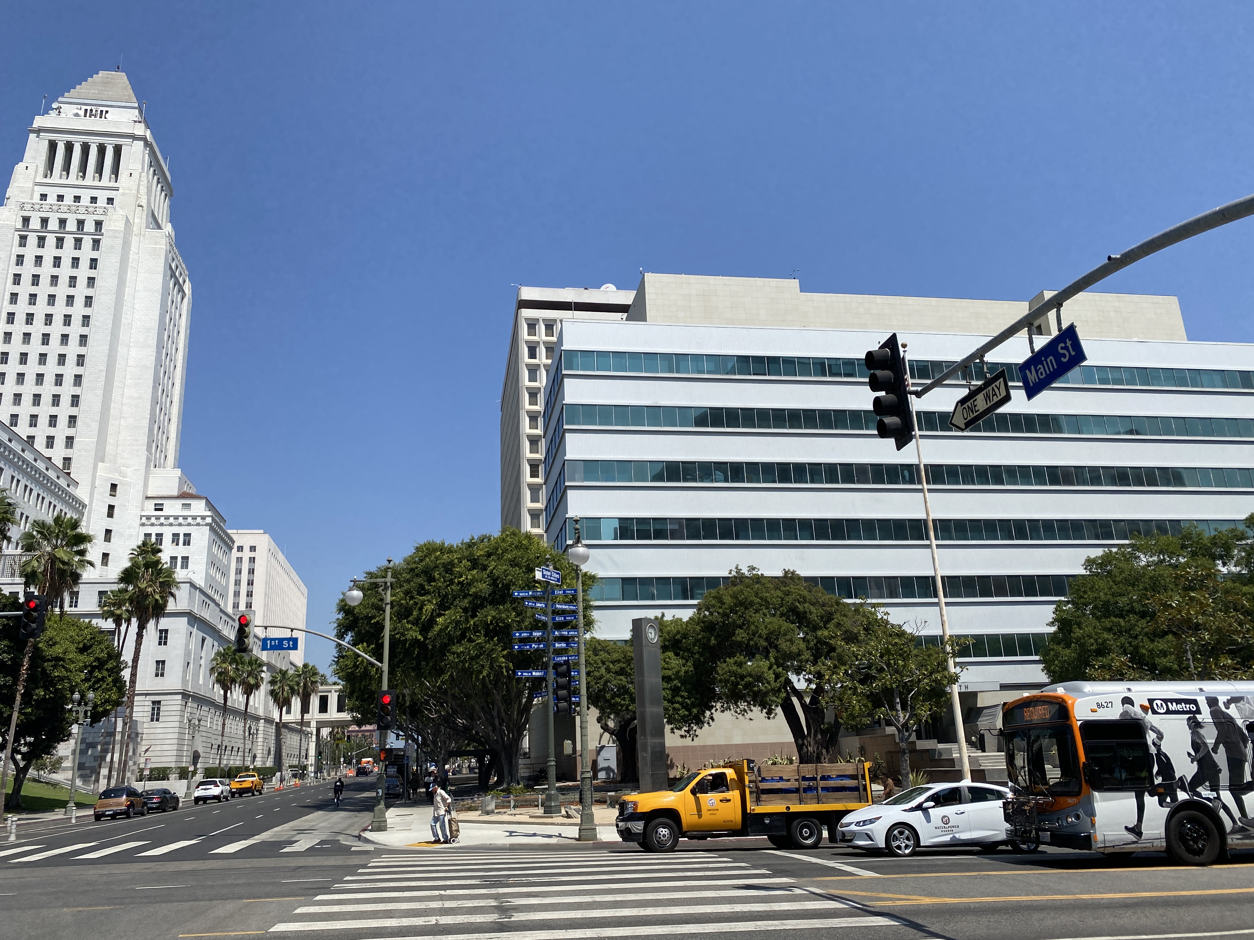 Street intersection in downtown Los Angeles with City Hall tower visible on the left.