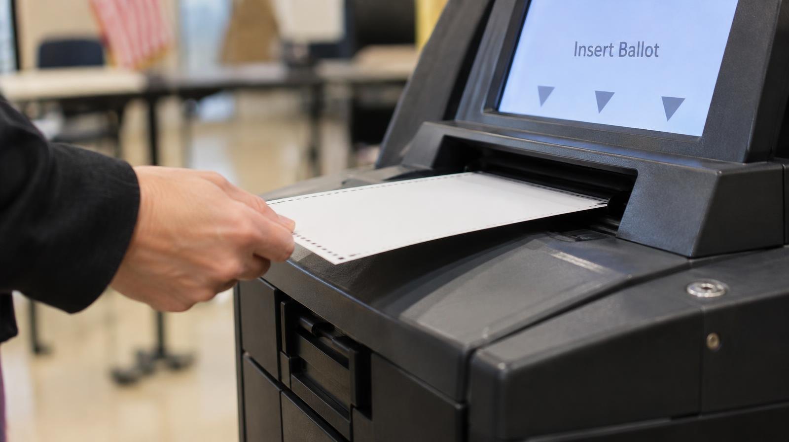 A paper ballot being inserted into a modern optical-scan voting machine.