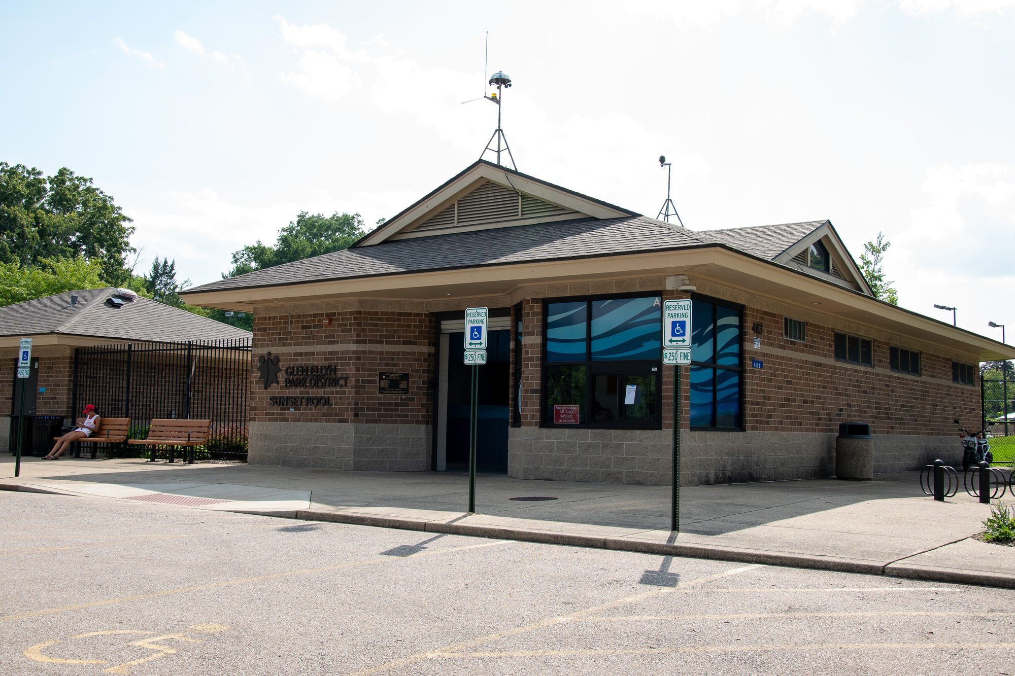 Single-story brick recreation center building with blue wave mural on entrance.