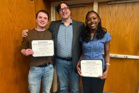Two students holding Outstanding Performer certificates pose with a third person indoors.