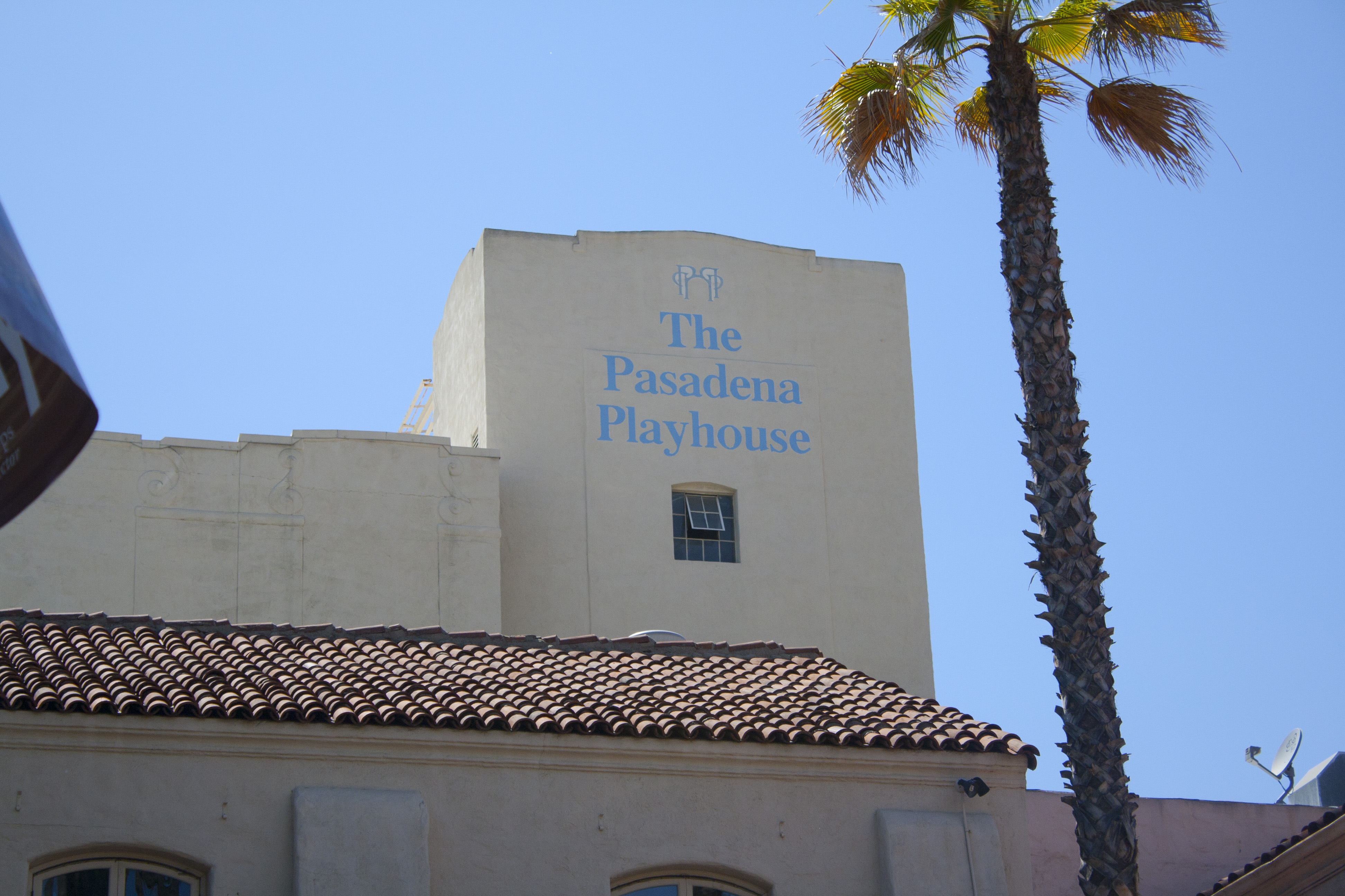 Spanish Colonial Revival facade of the Pasadena Playhouse with its name in blue letters.