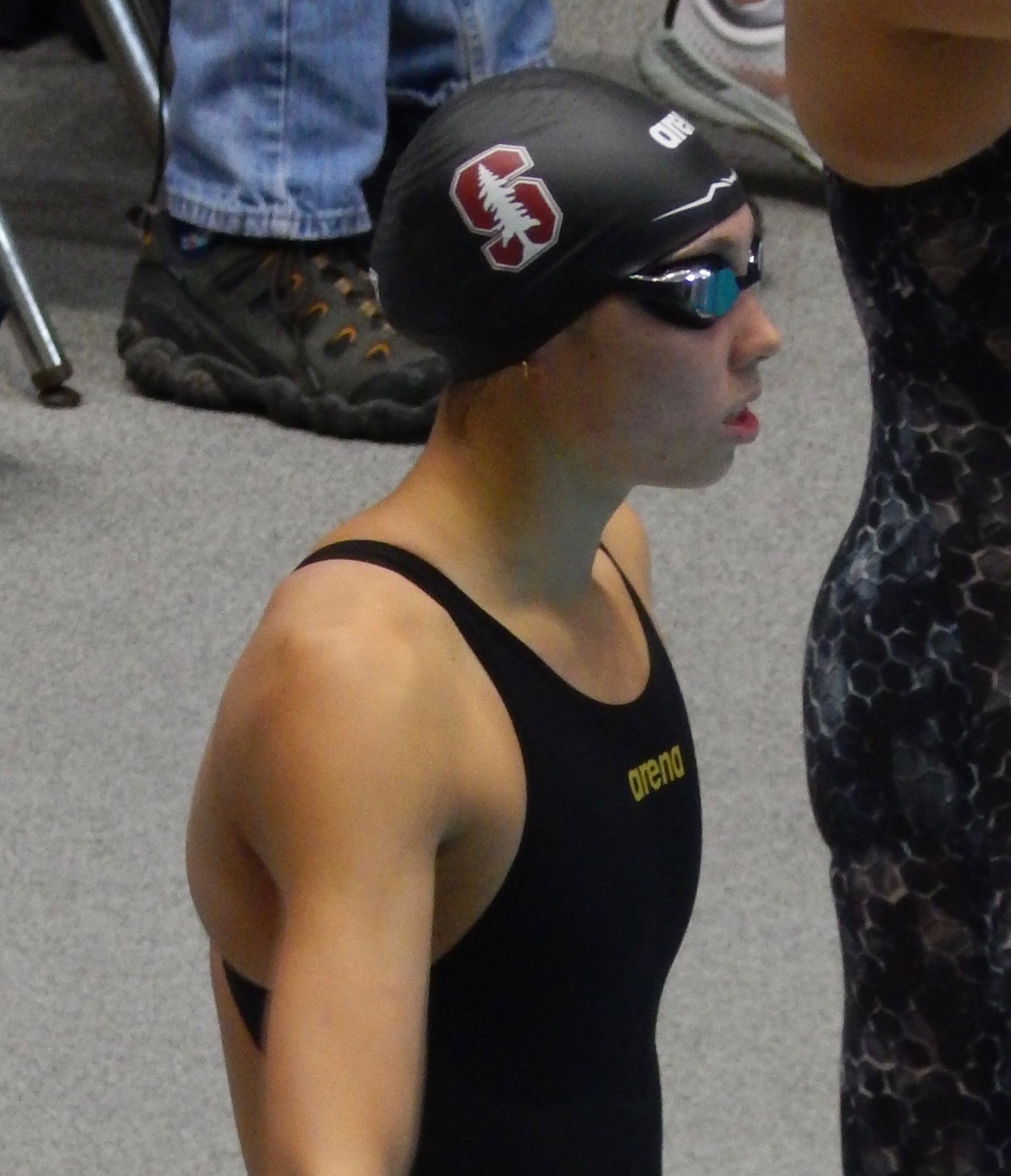 Torri Huske beside the starting block for lane 4 in the preliminaries of the 100 yard butterfly.