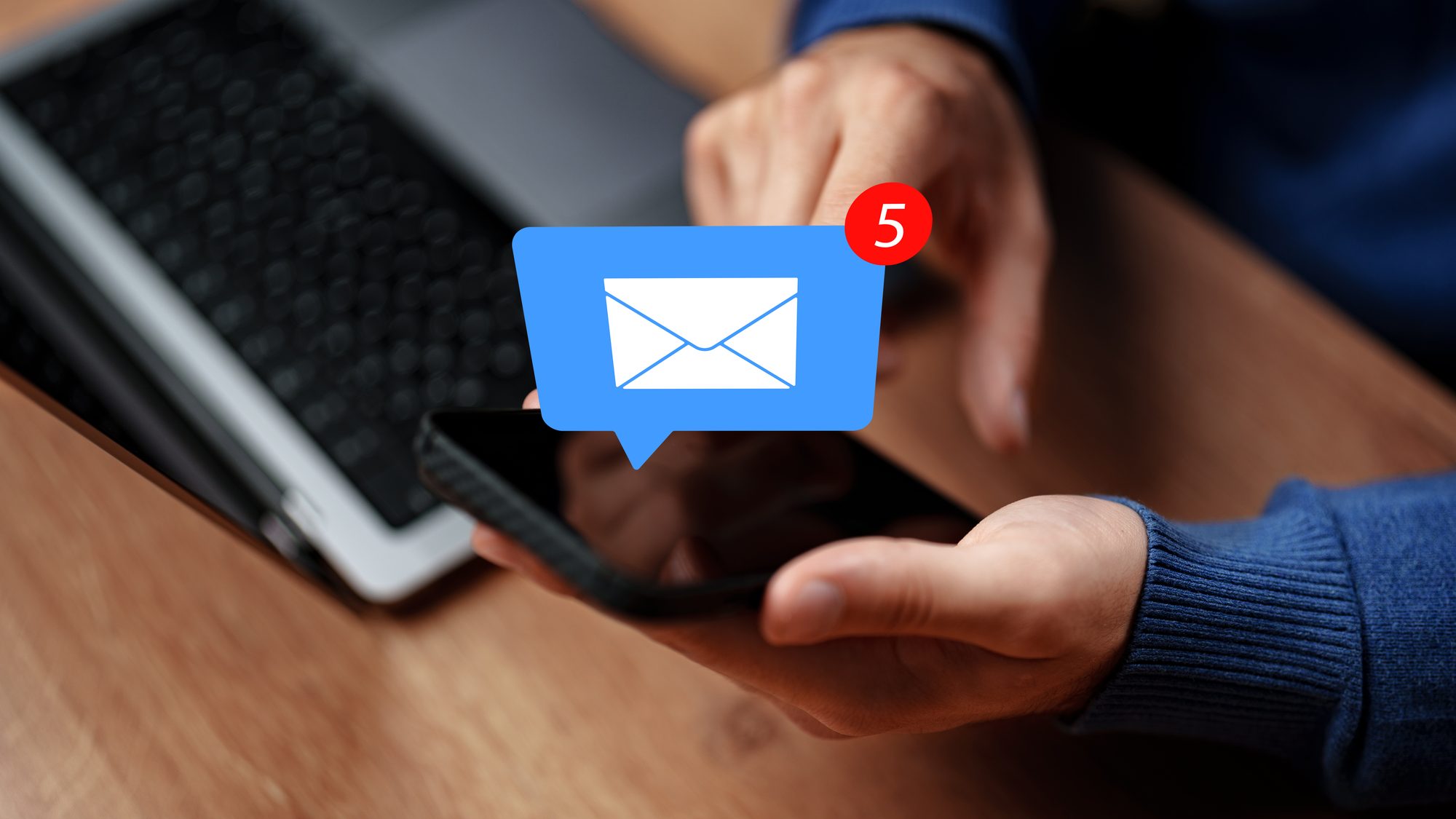 Person checks phone for message notifications while sitting at a desk