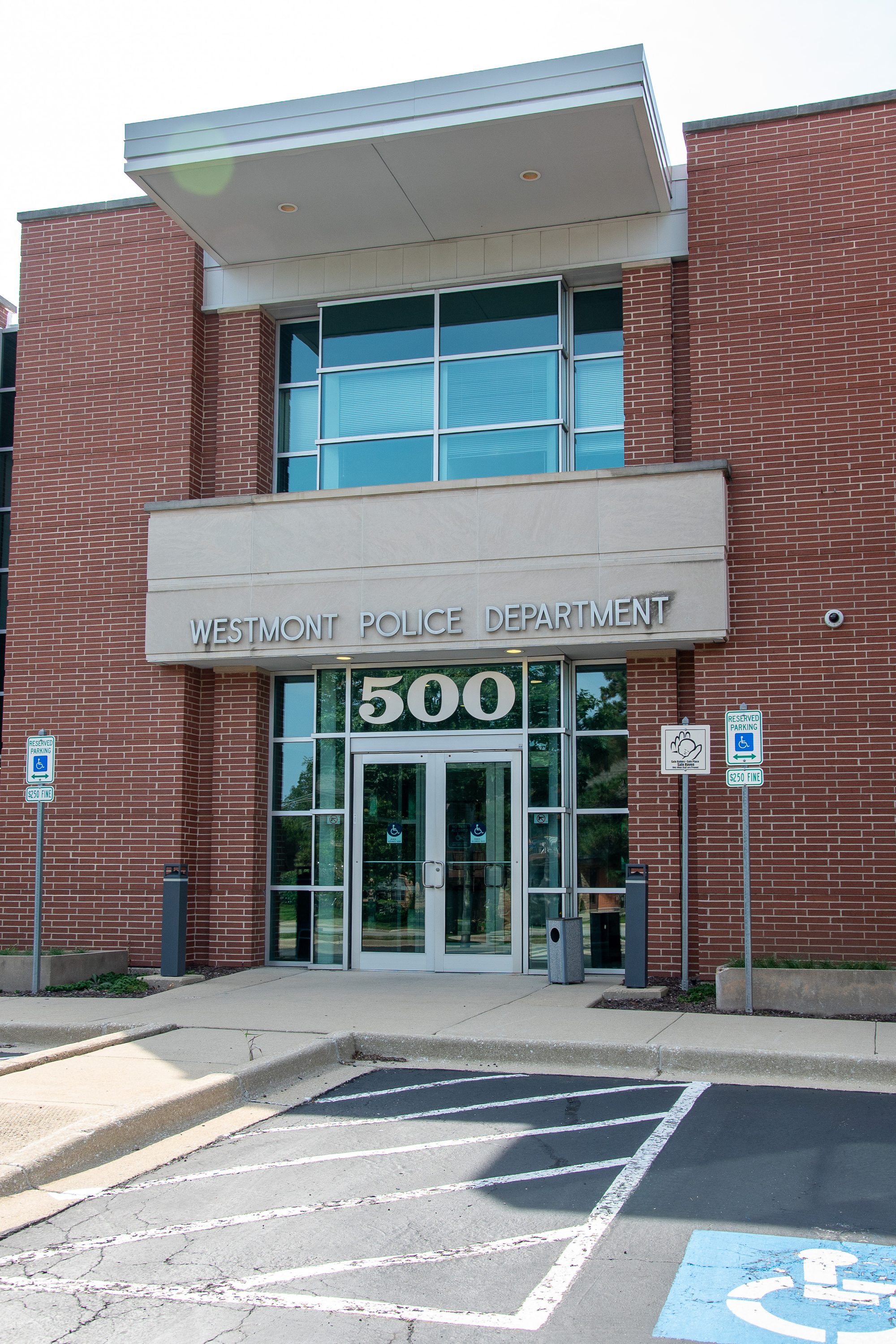 Exterior entrance of a brick police department building with glass doors.