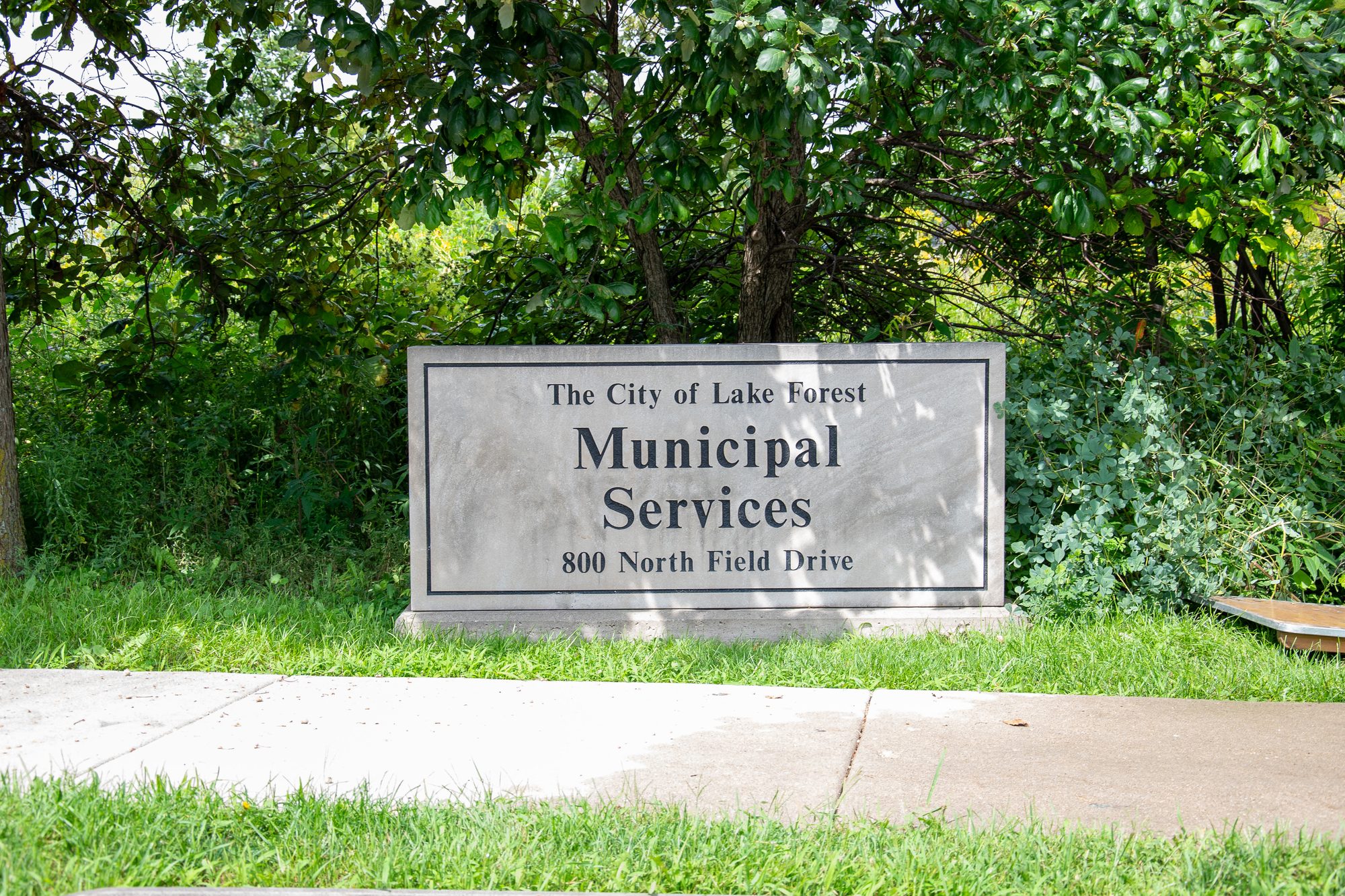 Stone monument sign for a municipal services building on a grass lawn