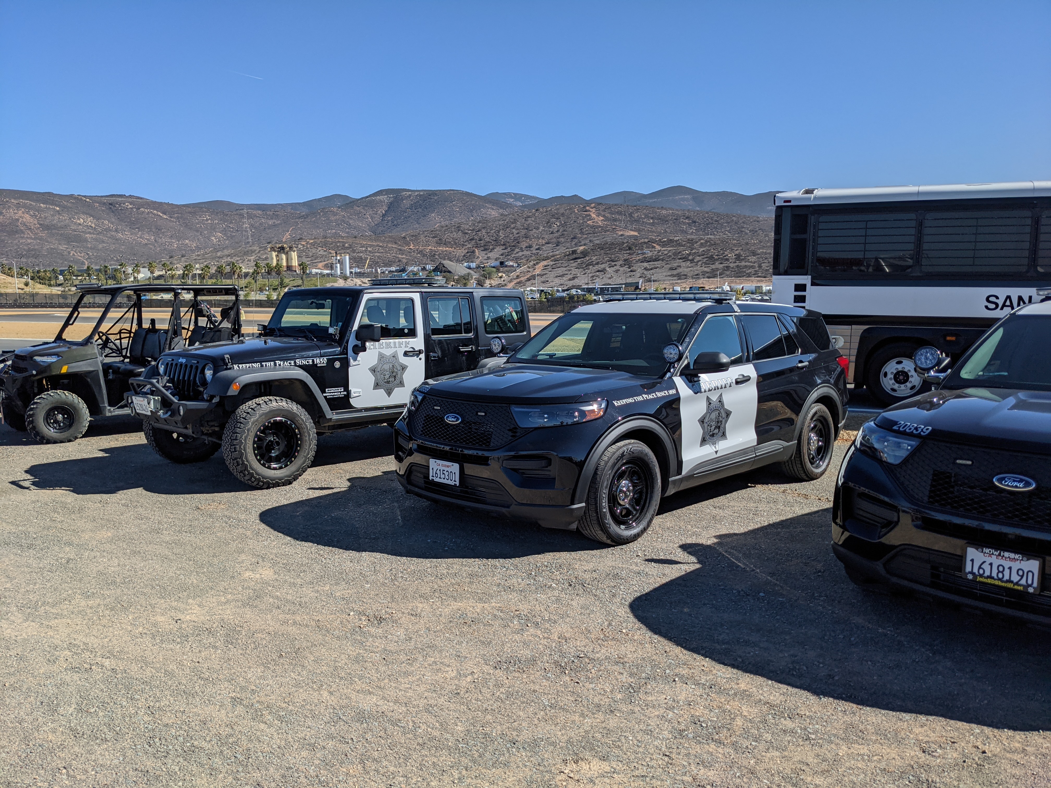 Several San Diego County Sheriff's Office vehicles parked on a gravel lot.