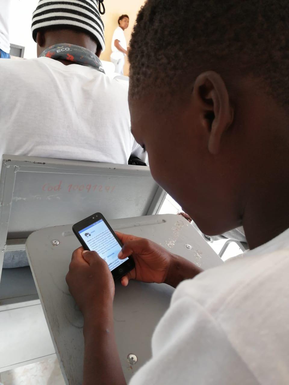A kid using his cellphone to get connected to Kiwix, an offline Wikipedia server. The offline server was installed on an old PC in a school of an afroecuadorian community, La Concepción - Carchi. Part of OfflinePedia project.