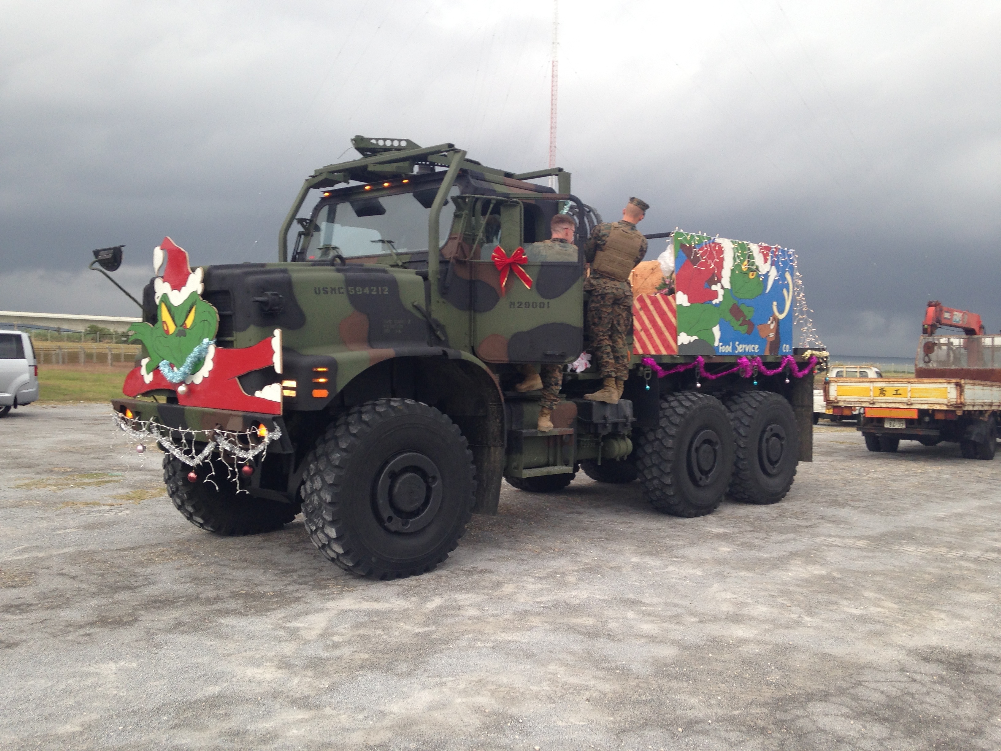 A large truck covered in colorful Christmas decorations and lights at a holiday event.