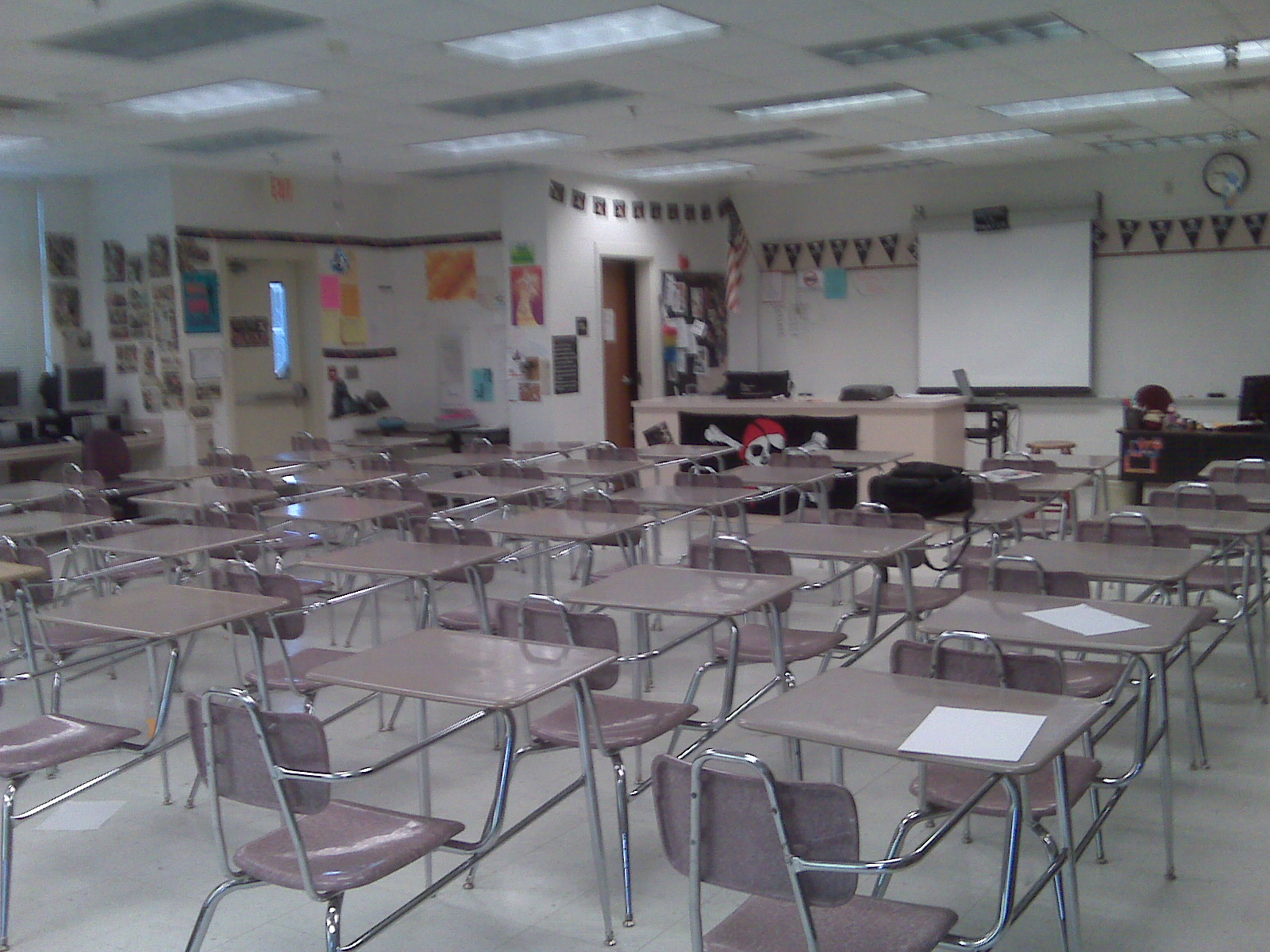 Empty high school classroom with rows of student desks and a whiteboard at the front.