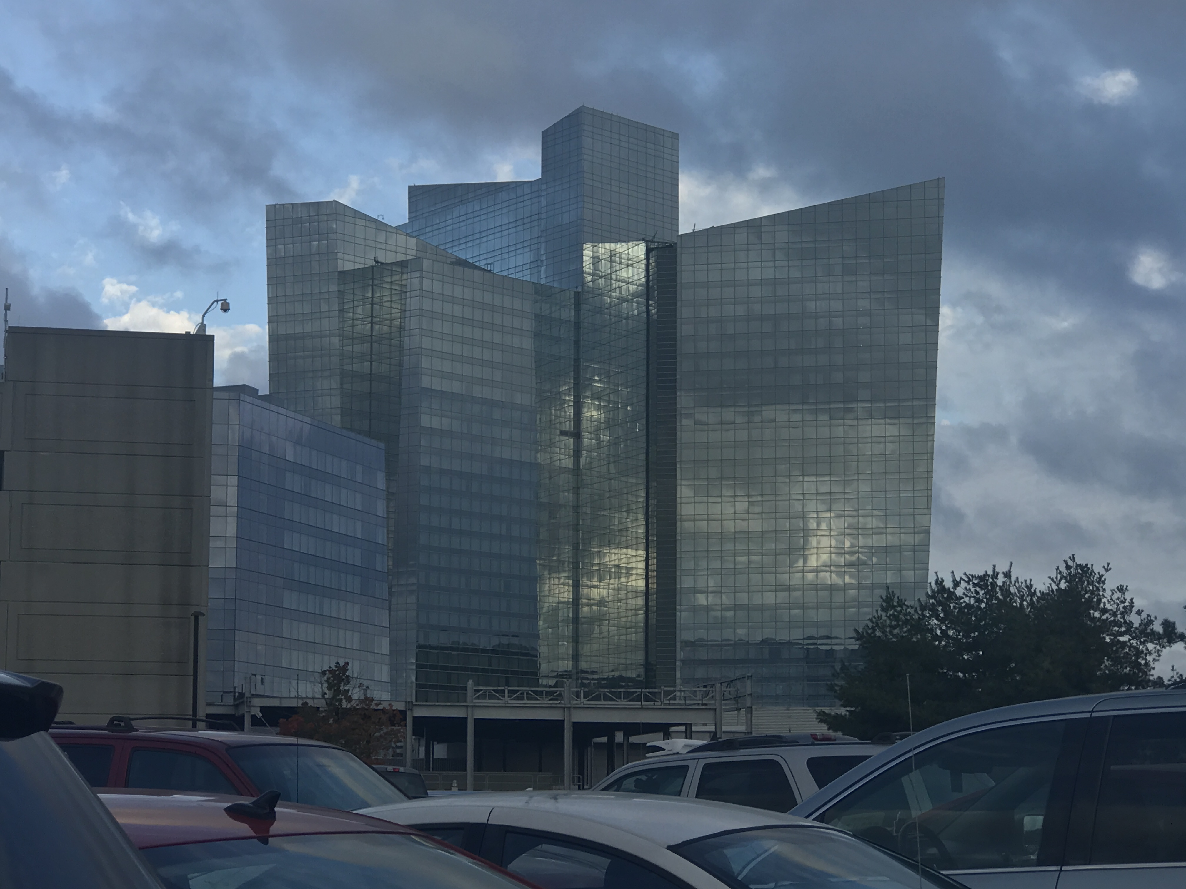 Tall glass-curtain-wall tower at Mohegan Sun casino under a cloudy sky.