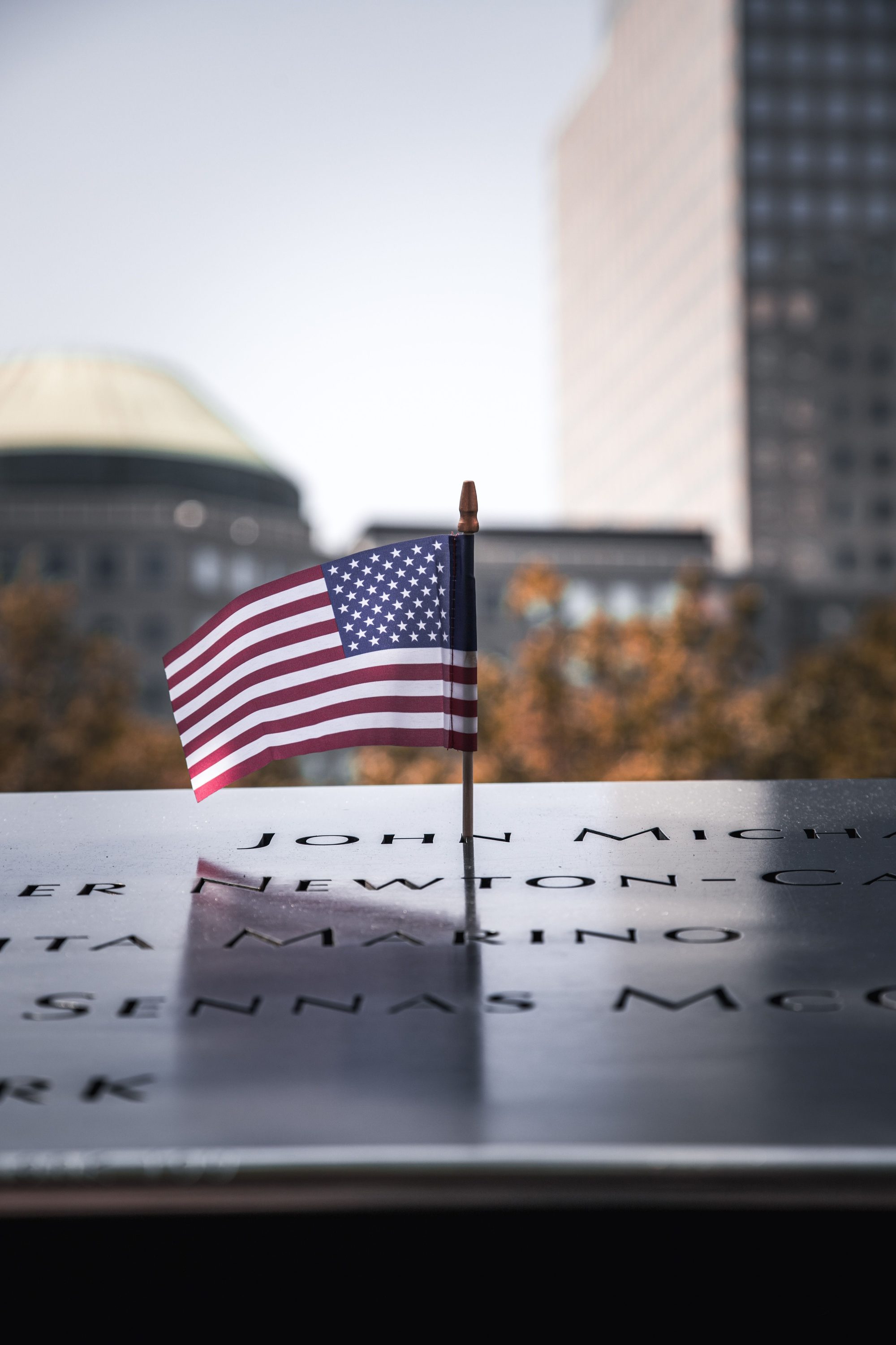 American flag placed at the 9/11 Memorial in New York City, symbolizing remembrance and patriotism.