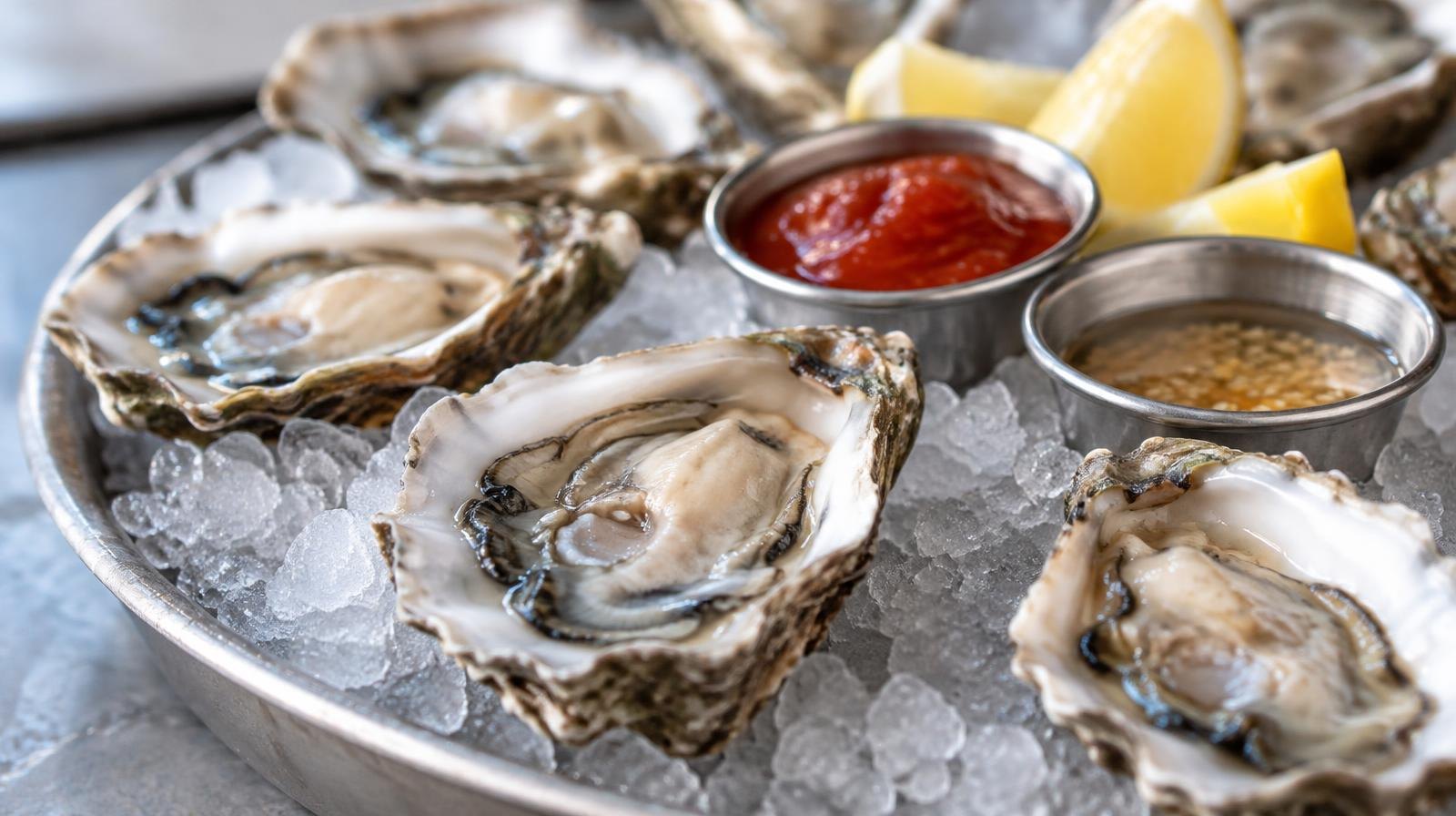 Fresh raw oysters on the half shell arranged on crushed ice.